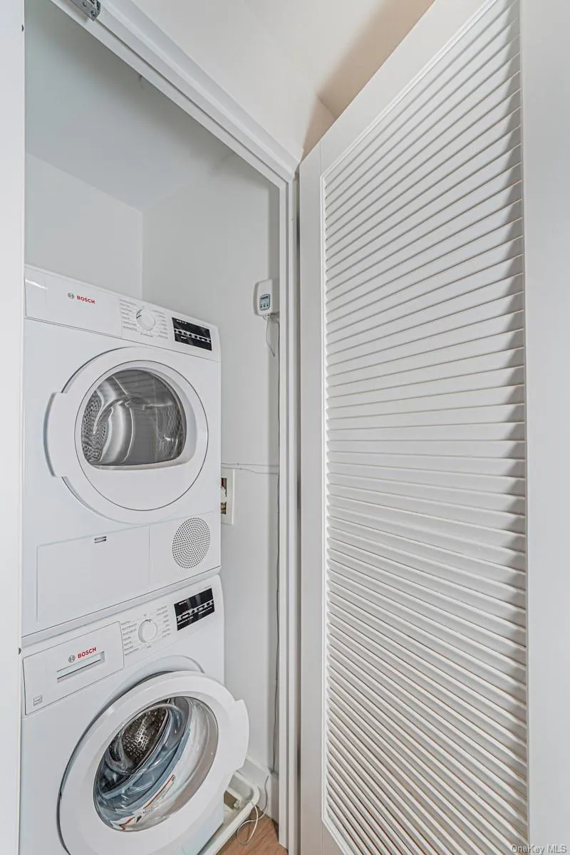 Laundry area with stacked washing machine and dryer Laundry area with stacked washing machine and dryer