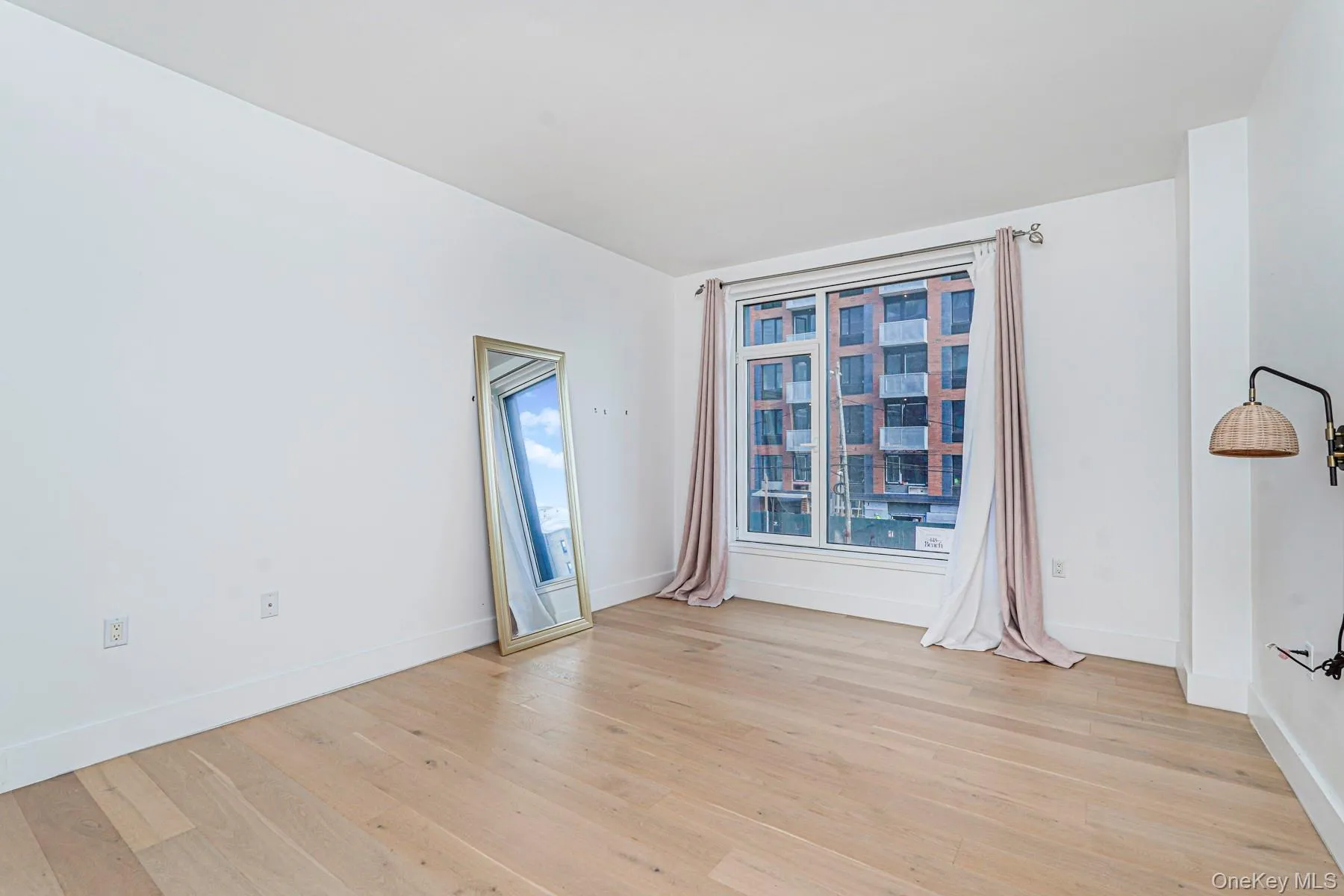 Unfurnished room with light wood-style floors and baseboards Unfurnished room with light wood-style floors and baseboards