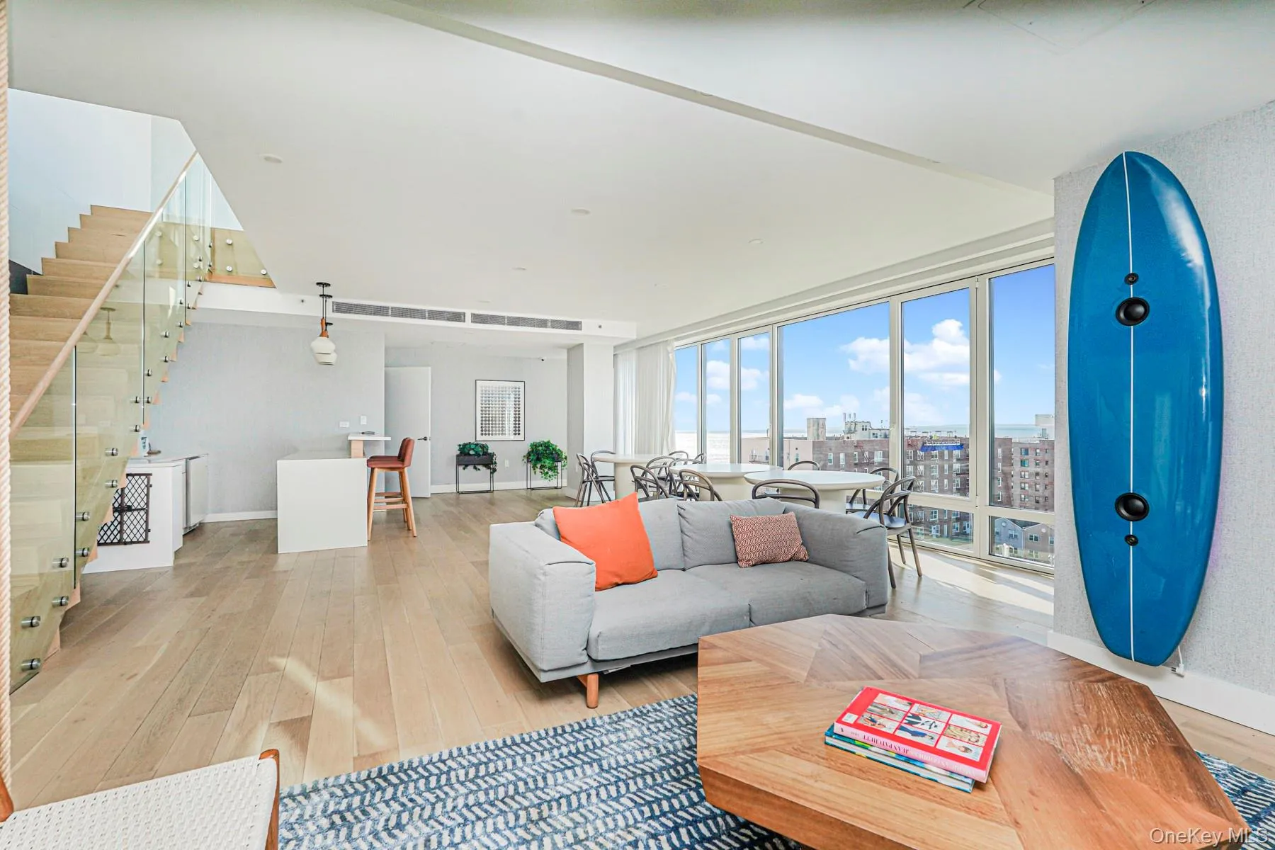 Living area featuring light wood-style flooring, a city view, and stairs Living area featuring light wood-style flooring, a city view, and stairs
