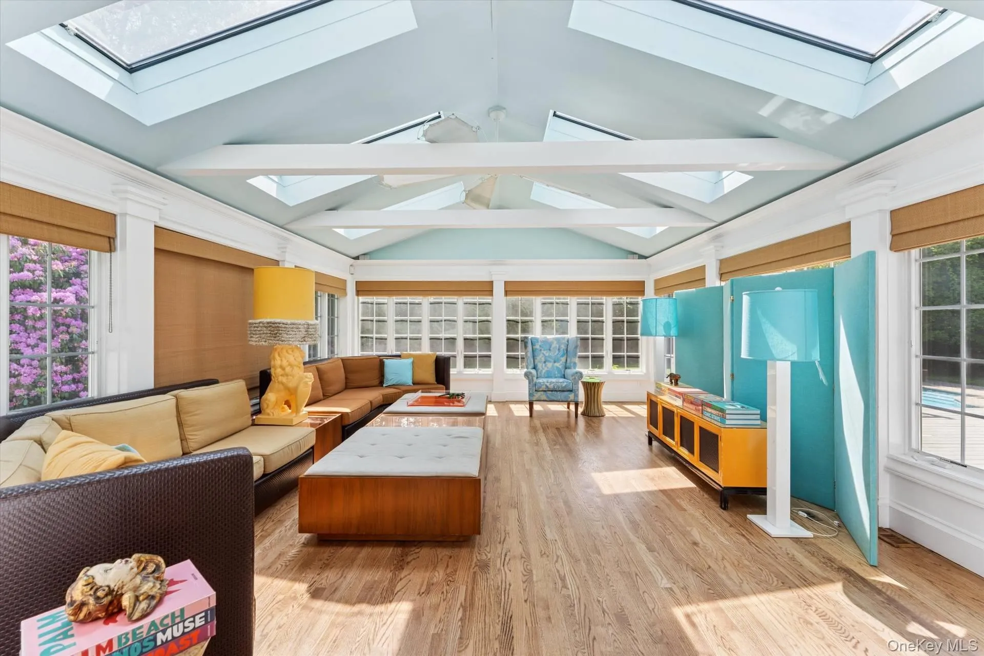 Sunroom / solarium featuring a skylight, wood finished floors, beamed ceiling, and high vaulted ceiling Sunroom / solarium featuring a skylight, wood finished floors, beamed ceiling, and high vaulted ceiling