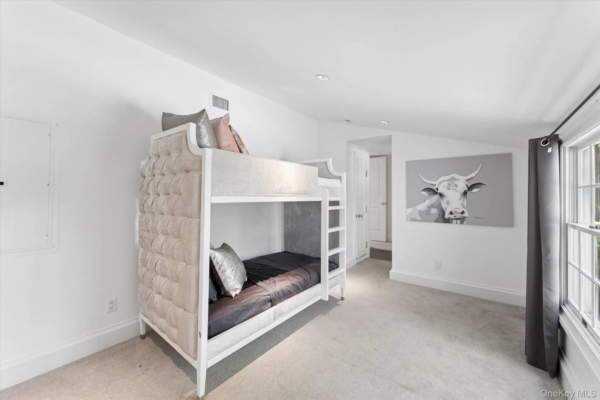 Unfurnished bedroom with lofted ceiling, light carpet, electric panel, and recessed lighting Unfurnished bedroom with lofted ceiling, light carpet, electric panel, and recessed lighting