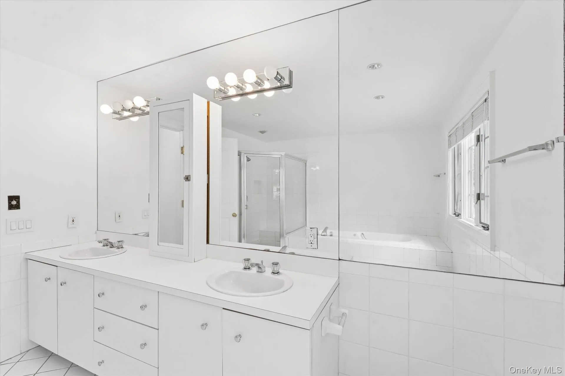 Bathroom featuring a bath, a stall shower, double vanity, and light tile patterned floors Bathroom featuring a bath, a stall shower, double vanity, and light tile patterned floors