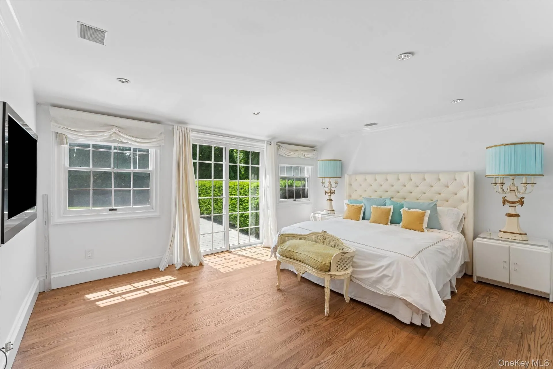 Bedroom with access to exterior, light wood finished floors, and crown molding Bedroom with access to exterior, light wood finished floors, and crown molding