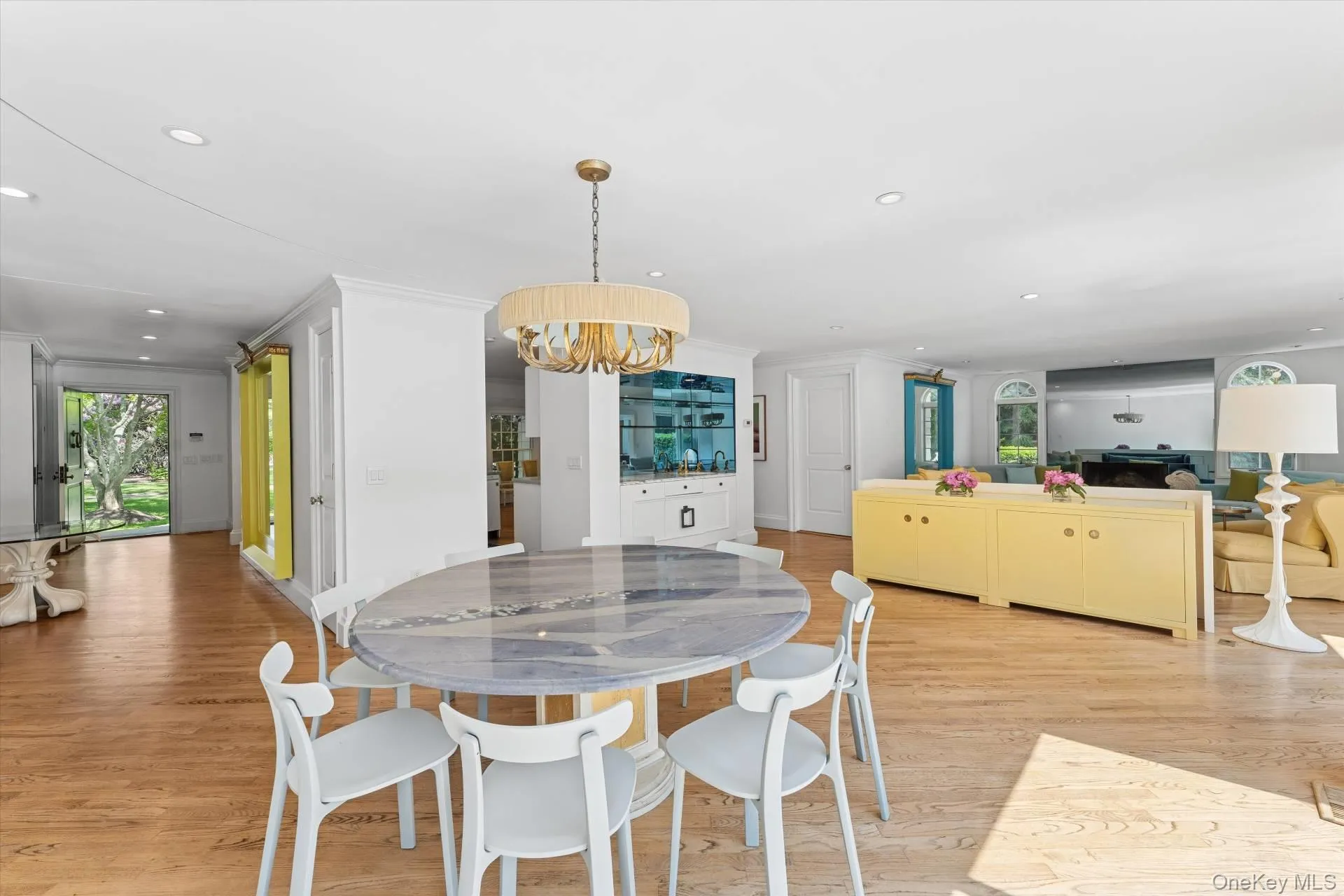 Dining space with light wood-style floors, recessed lighting, a chandelier, and ornamental molding Dining space with light wood-style floors, recessed lighting, a chandelier, and ornamental molding