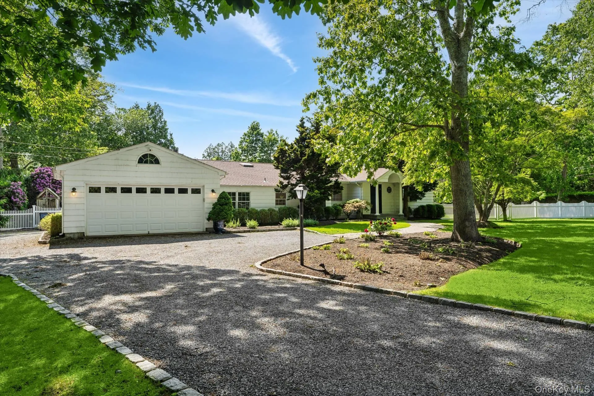 View of front facade with gravel driveway and an attached two car garage View of front facade with gravel driveway and an attached two car garage