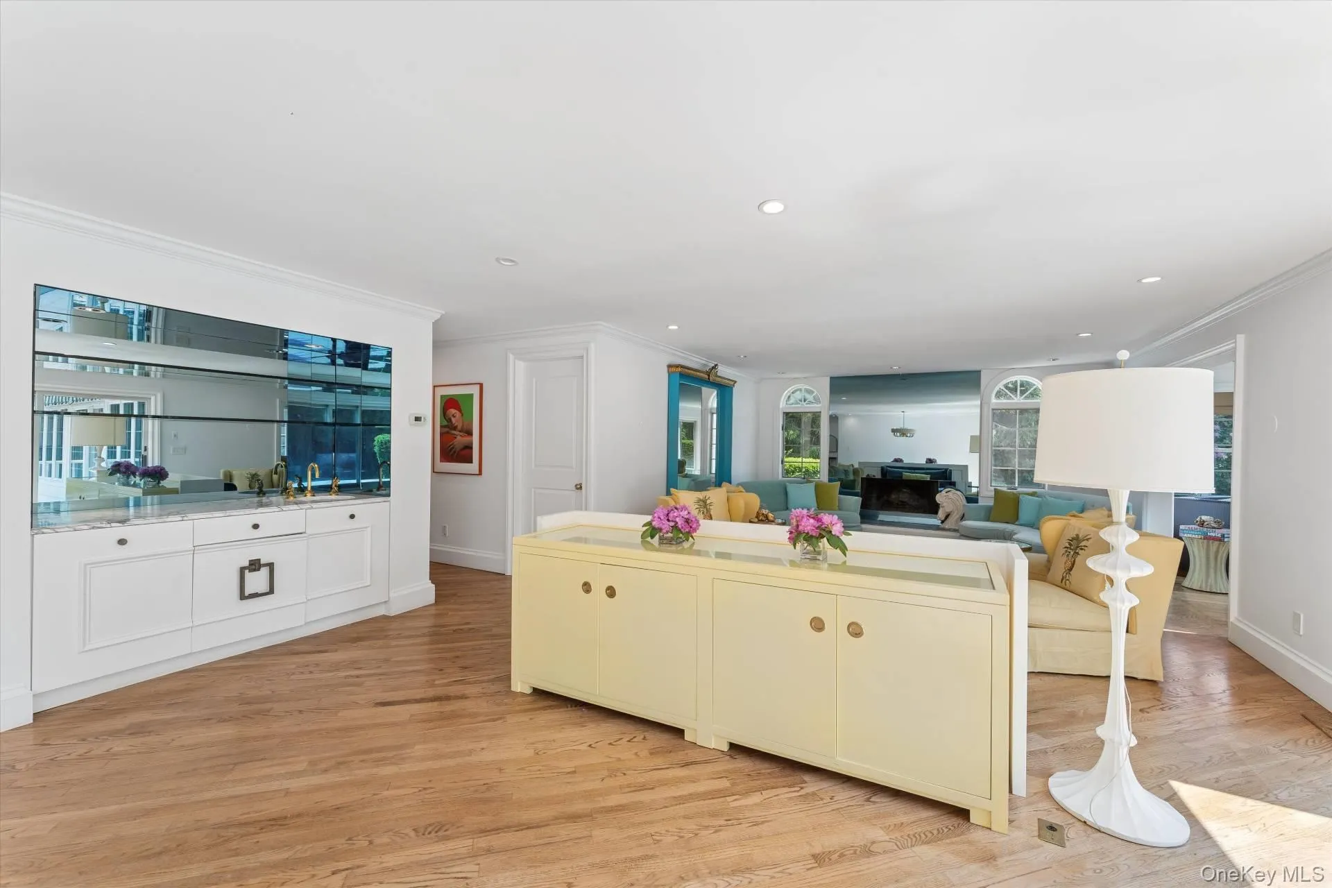 Kitchen featuring crown molding, light wood finished floors, recessed lighting, open floor plan, and white cabinetry Kitchen featuring crown molding, light wood finished floors, recessed lighting, open floor plan, and white cabinetry