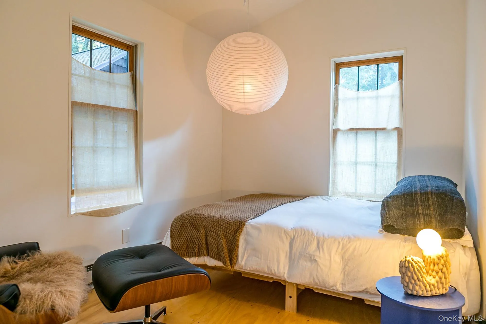 Bedroom featuring multiple windows and wood finished floors Bedroom featuring multiple windows and wood finished floors