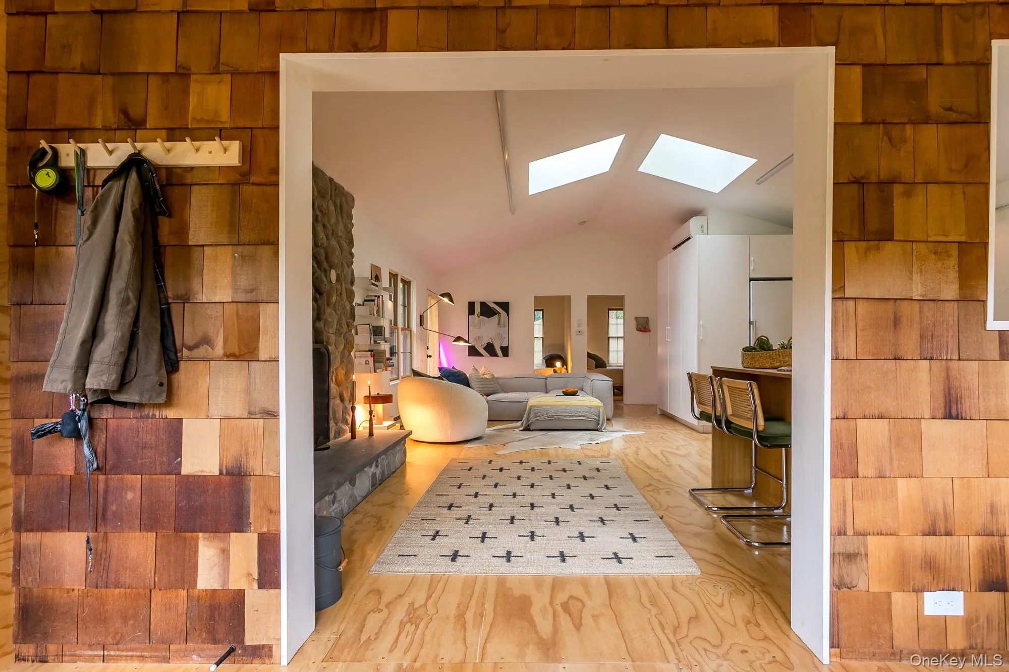 Living room with a skylight, wood finished floors, and high vaulted ceiling Living room with a skylight, wood finished floors, and high vaulted ceiling