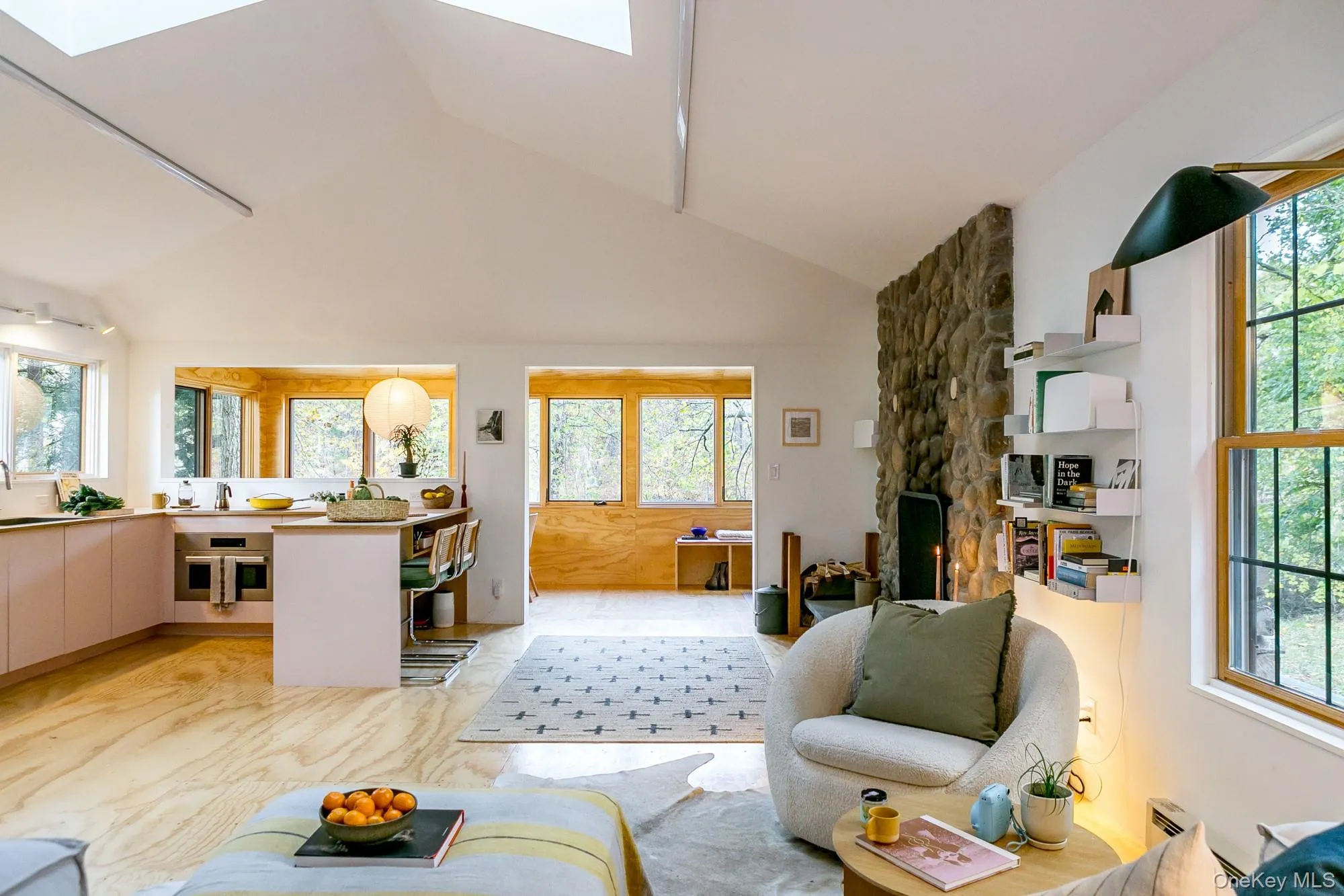 Living area with a skylight, a fireplace, and high vaulted ceiling Living area with a skylight, a fireplace, and high vaulted ceiling