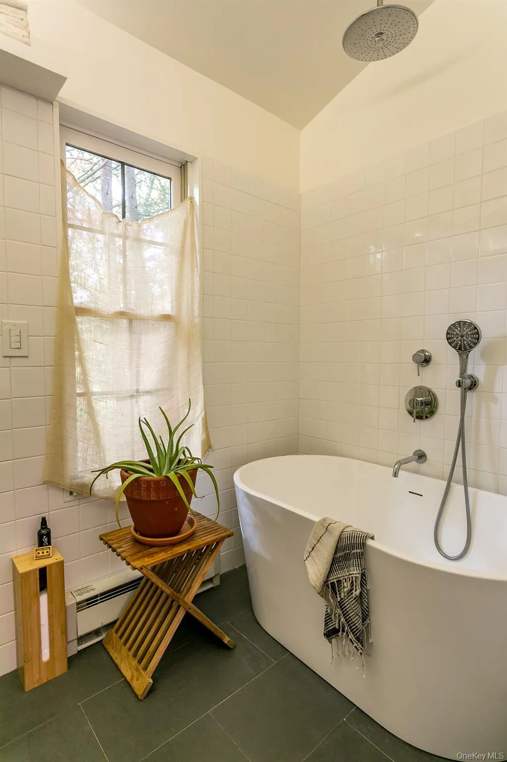 Full bath with tile walls, tile patterned flooring, and a soaking tub Full bath with tile walls, tile patterned flooring, and a soaking tub