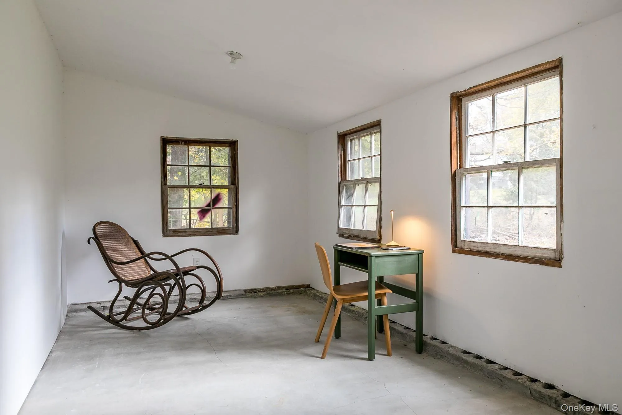 Living area with vaulted ceiling and concrete flooring Living area with vaulted ceiling and concrete flooring