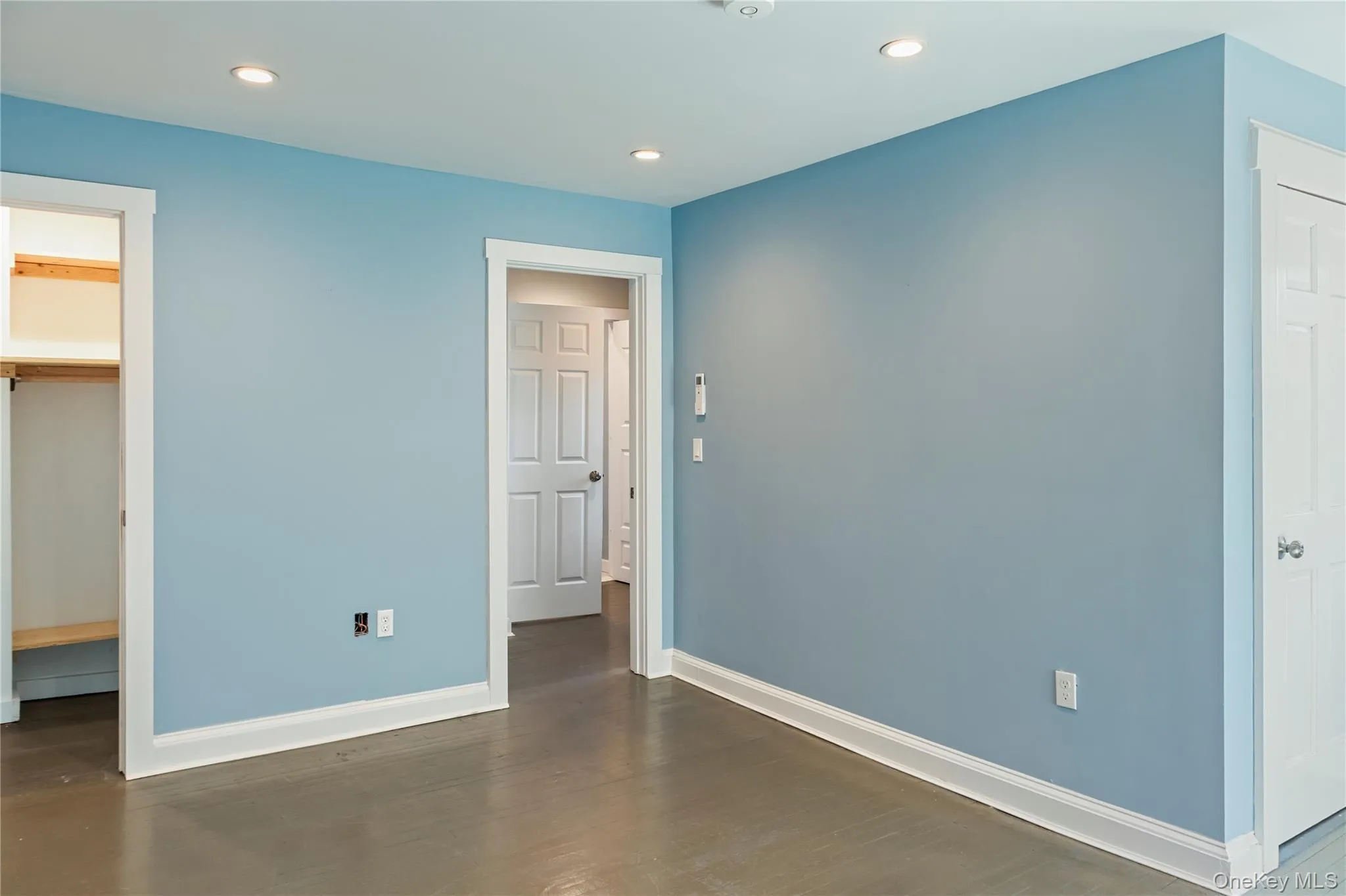 Unfurnished bedroom featuring recessed lighting, dark wood-type flooring, and a spacious closet Unfurnished bedroom featuring recessed lighting, dark wood-type flooring, and a spacious closet