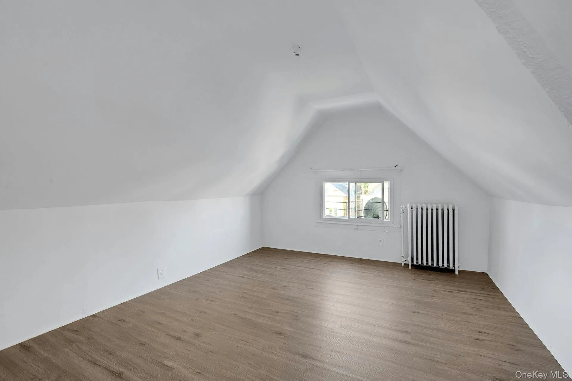 Bonus room with radiator heating unit, wood finished floors, and lofted ceiling Bonus room with radiator heating unit, wood finished floors, and lofted ceiling