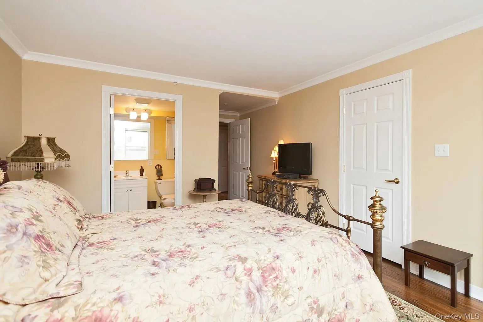 Bedroom with ornamental molding and dark wood finished floors Bedroom with ornamental molding and dark wood finished floors