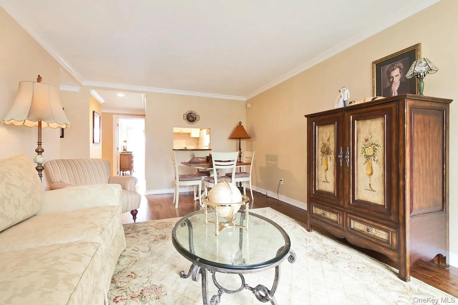Living area with light wood-style flooring and crown molding Living area with light wood-style flooring and crown molding