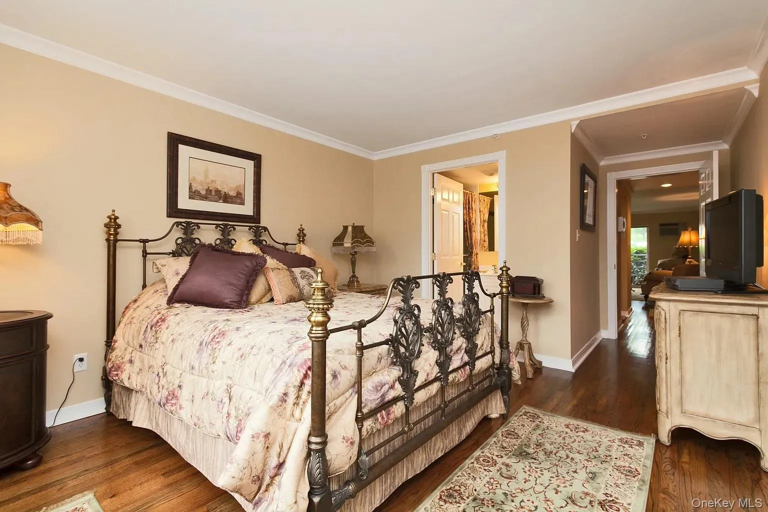 Bedroom featuring ornamental molding and dark wood-style flooring Bedroom featuring ornamental molding and dark wood-style flooring