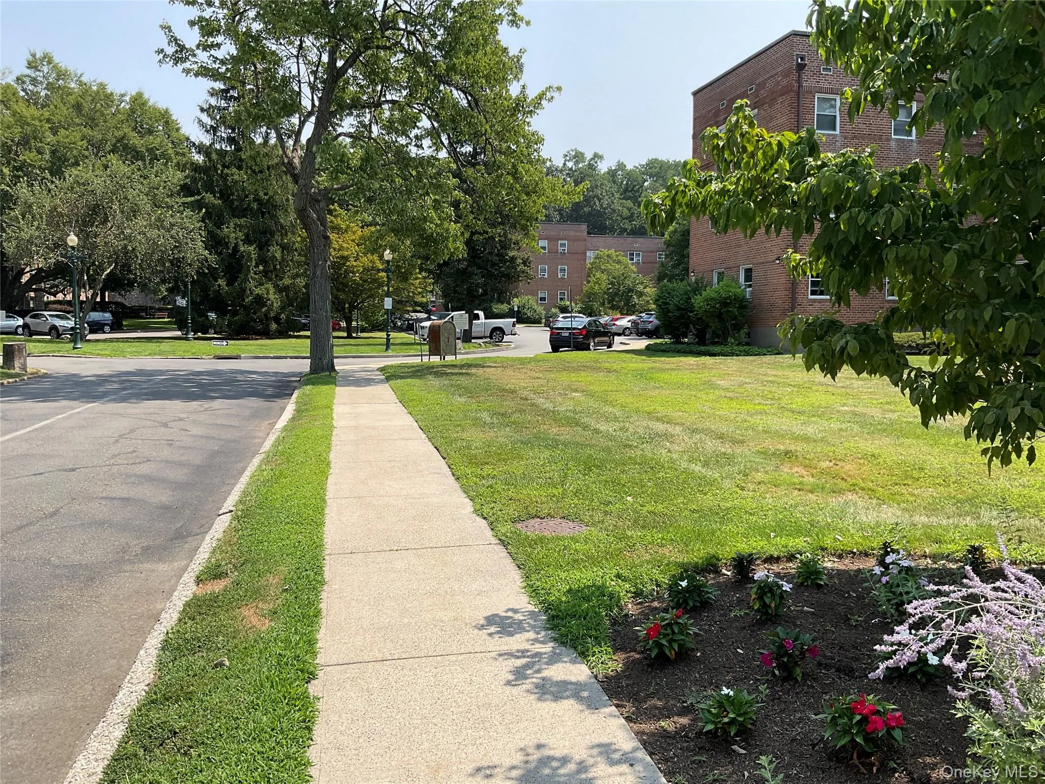 View of asphalt road featuring street lights and sidewalks View of asphalt road featuring street lights and sidewalks