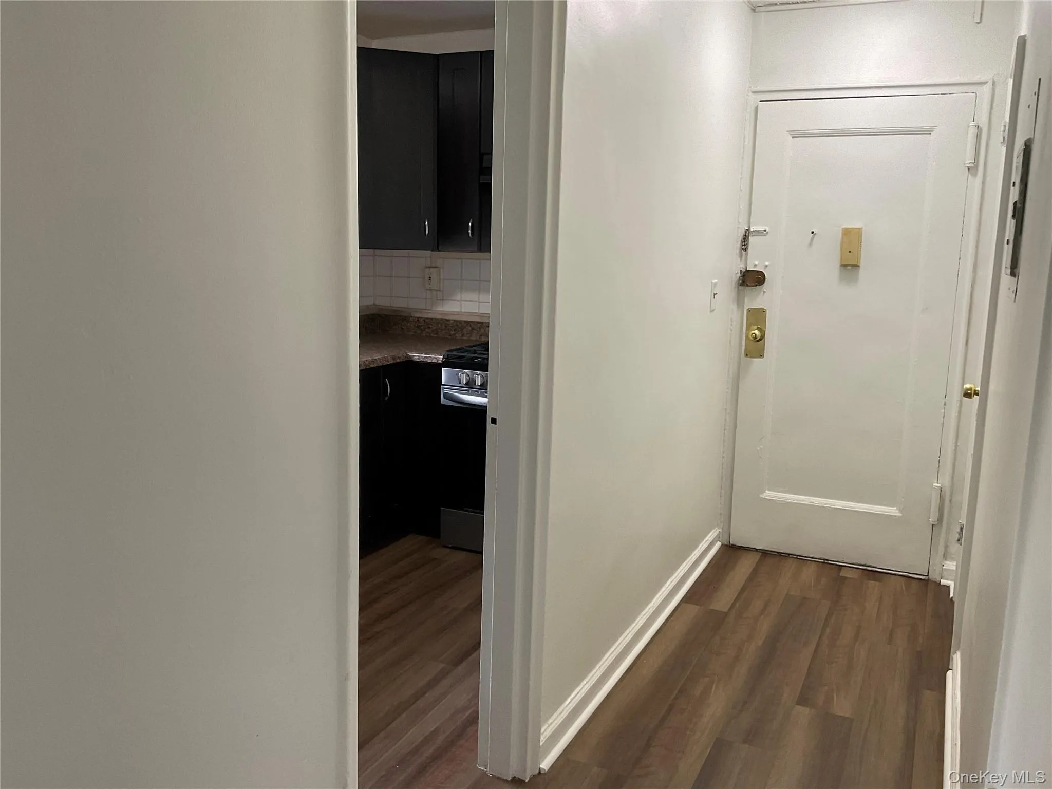 Hall with dark wood-type flooring and baseboards Hall with dark wood-type flooring and baseboards