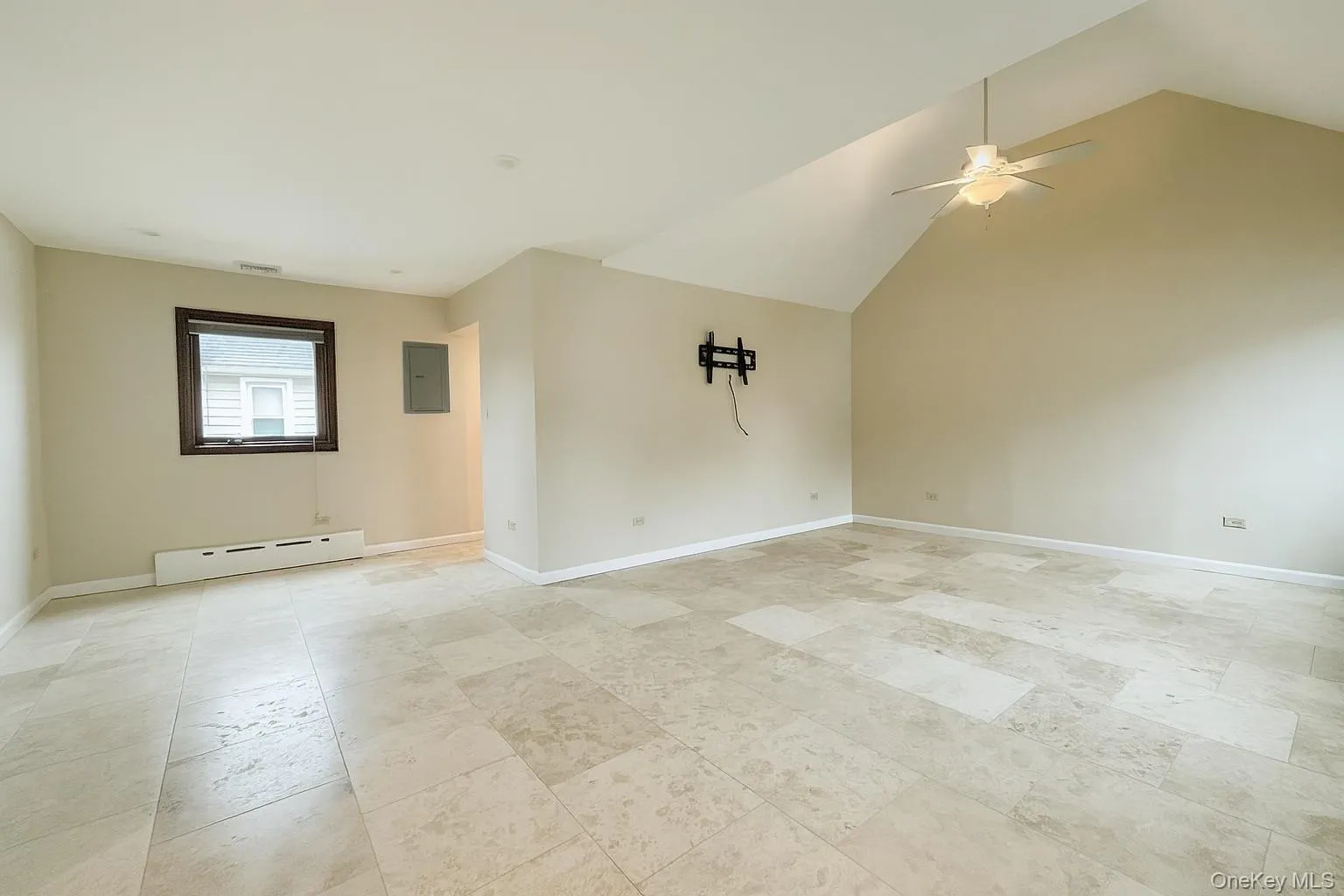 Spare room featuring a baseboard radiator, electric panel, vaulted ceiling, and ceiling fan Spare room featuring a baseboard radiator, electric panel, vaulted ceiling, and ceiling fan