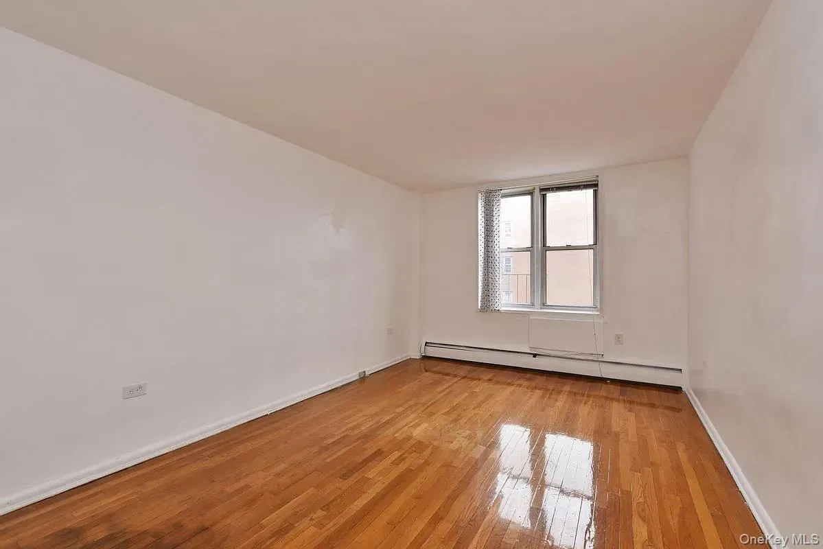 Unfurnished room featuring light wood-style floors and a baseboard heating unit Unfurnished room featuring light wood-style floors and a baseboard heating unit