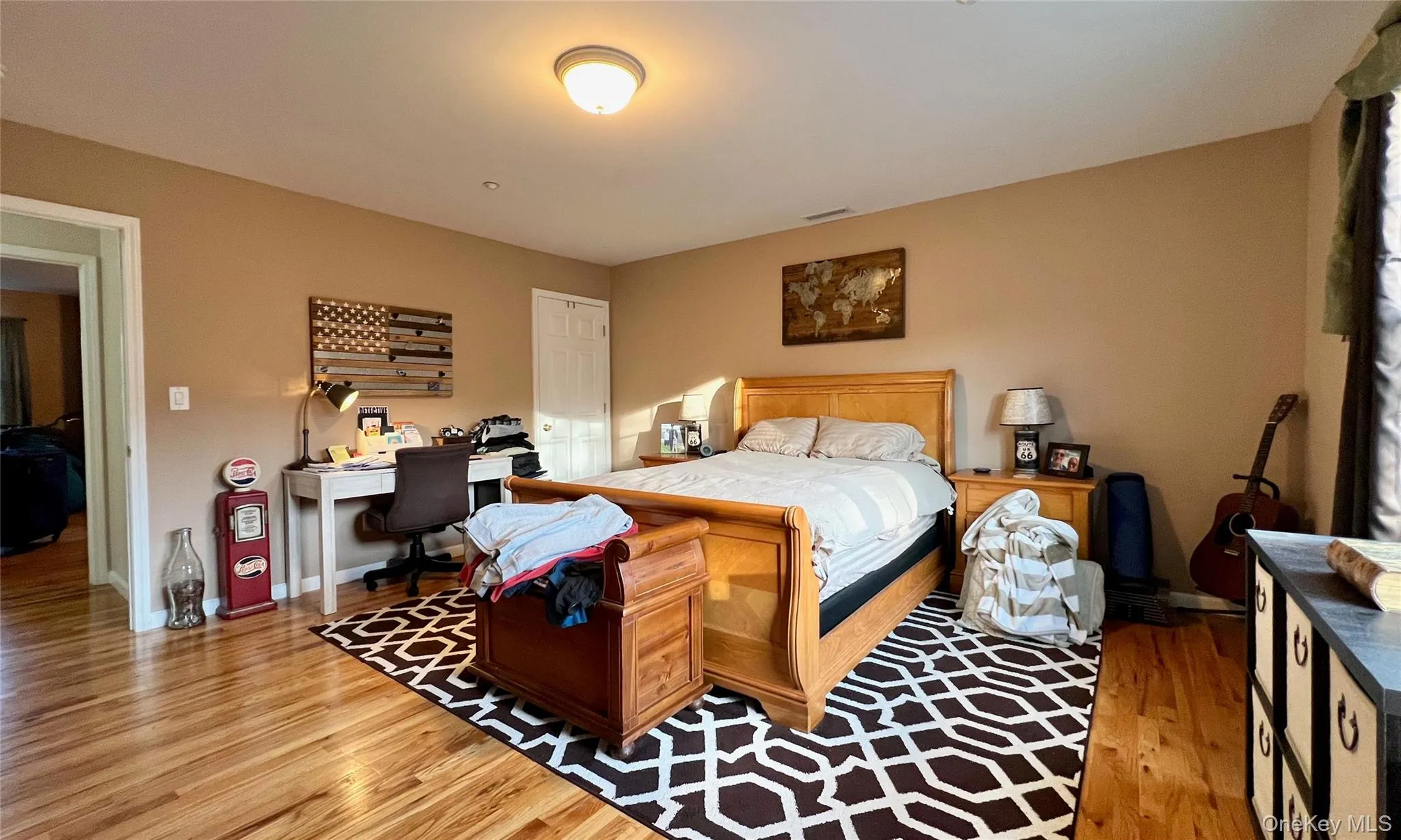 Bedroom featuring light wood finished floors and a desk Bedroom featuring light wood finished floors and a desk
