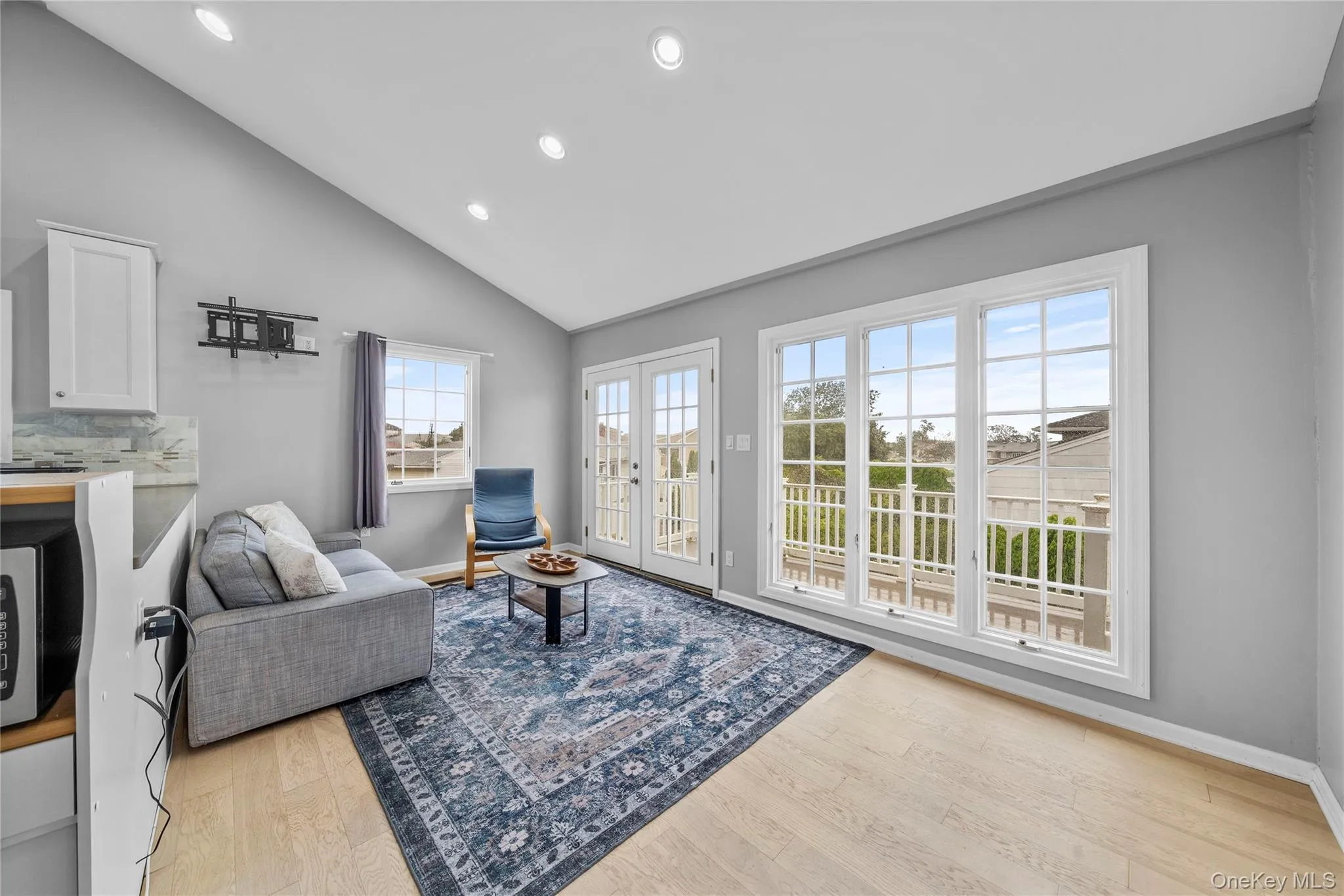 Sitting room with recessed lighting, light wood-style floors, french doors, and high vaulted ceiling Sitting room with recessed lighting, light wood-style floors, french doors, and high vaulted ceiling