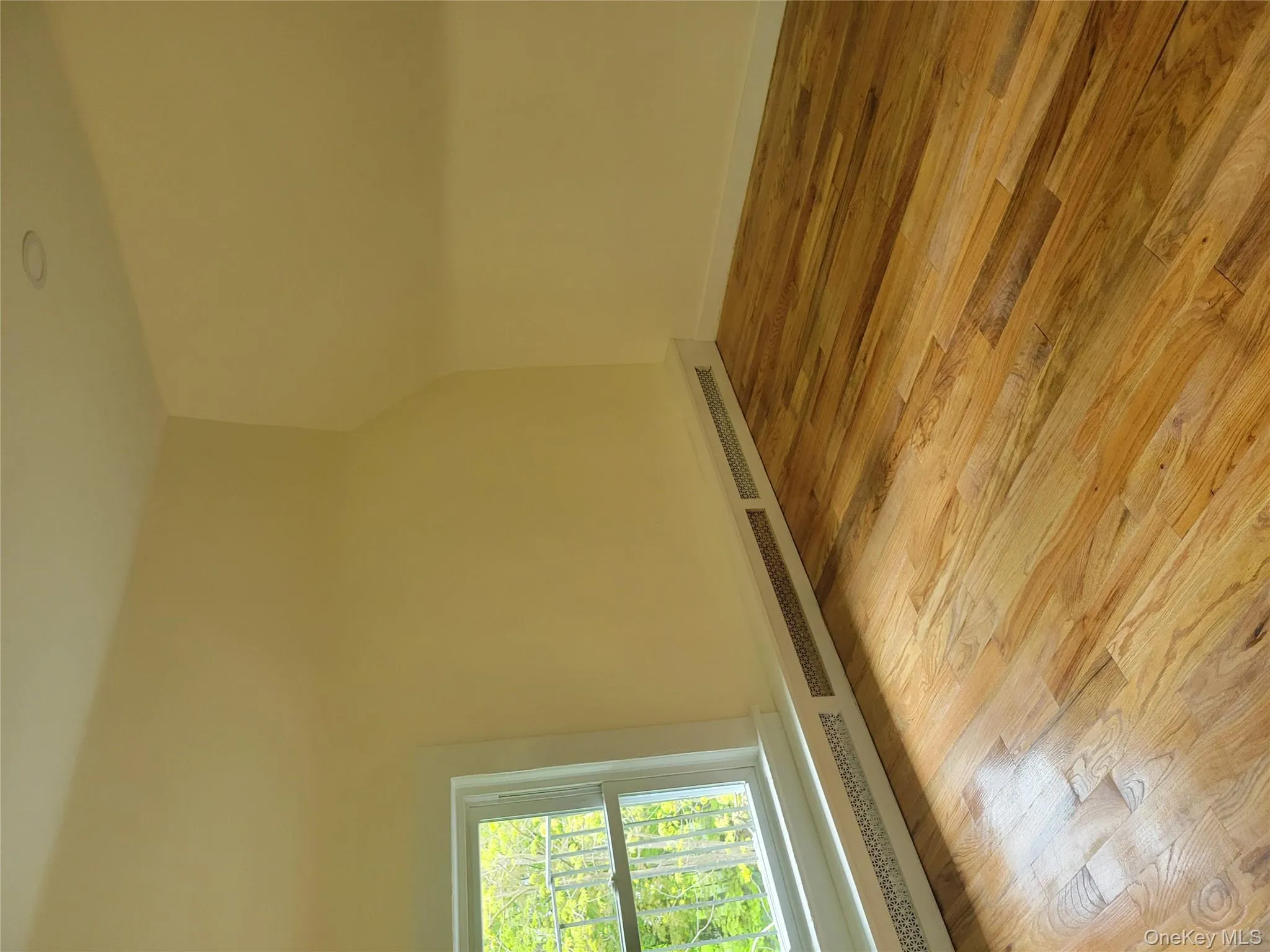 Bonus room with a baseboard radiator and light wood finished floors Bonus room with a baseboard radiator and light wood finished floors