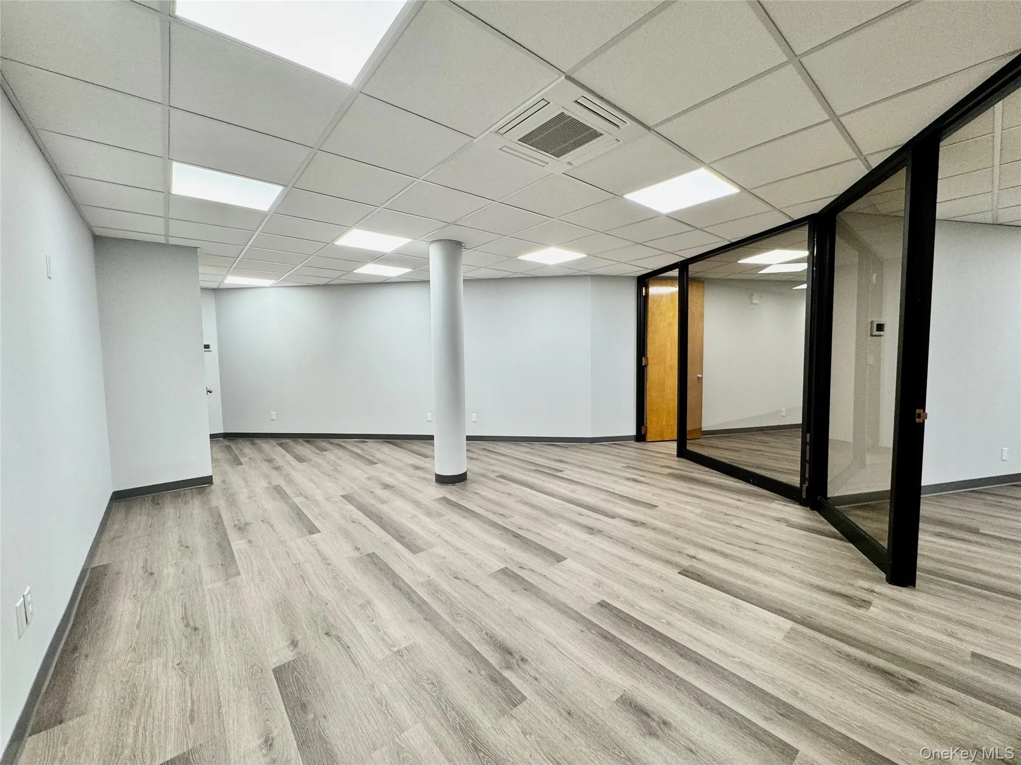 Finished basement featuring light wood-type flooring and a paneled ceiling Finished basement featuring light wood-type flooring and a paneled ceiling
