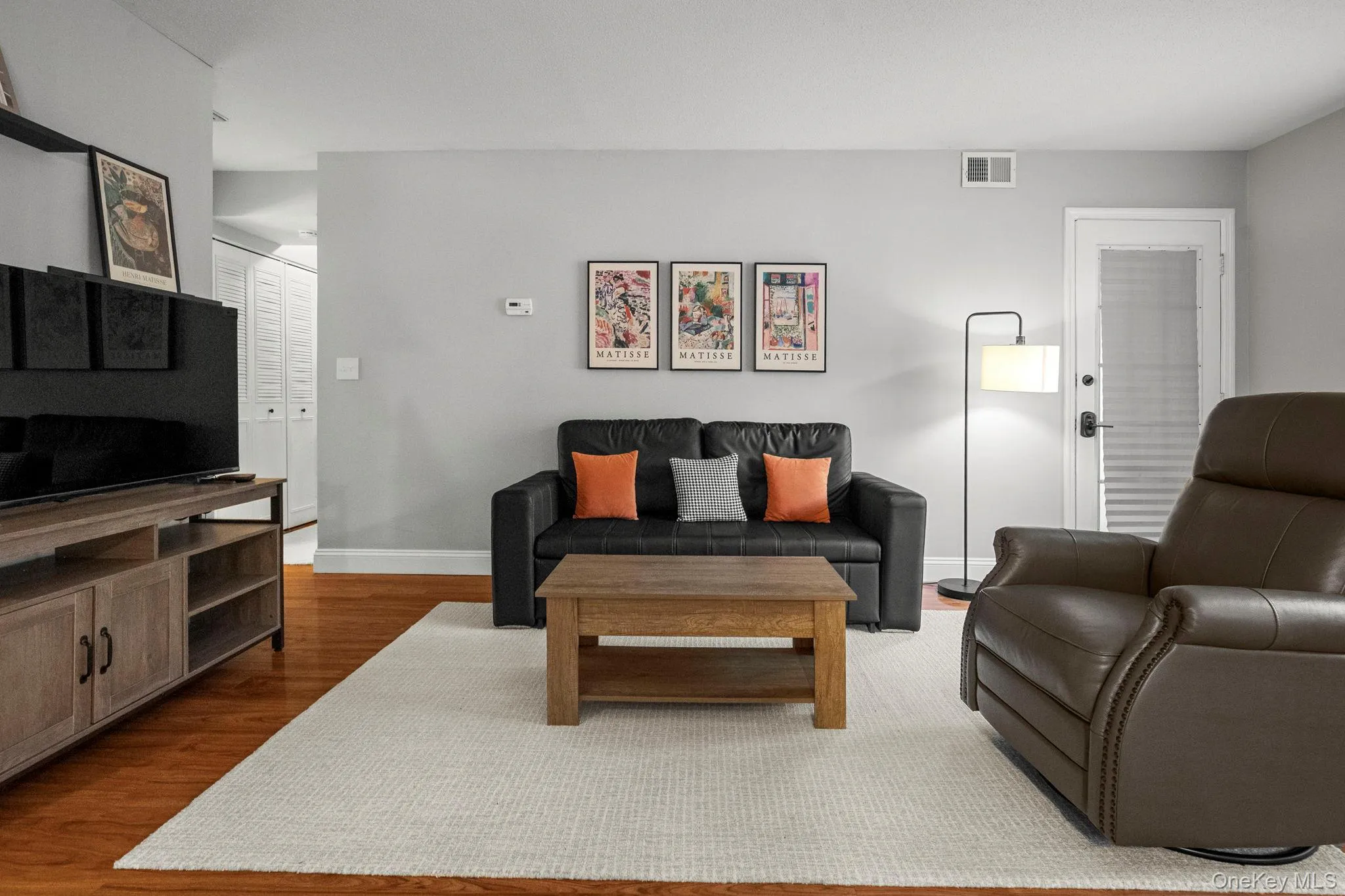 The spacious living room features rich flooring, contemporary finishes, and easy access to the private patio for indoor-outdoor enjoyment. The spacious living room features rich flooring, contemporary finishes, and easy access to the private patio for indoor-outdoor enjoyment.