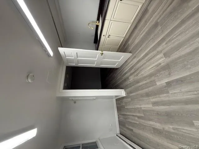 Basement with a baseboard heating unit and light wood-type flooring Basement with a baseboard heating unit and light wood-type flooring