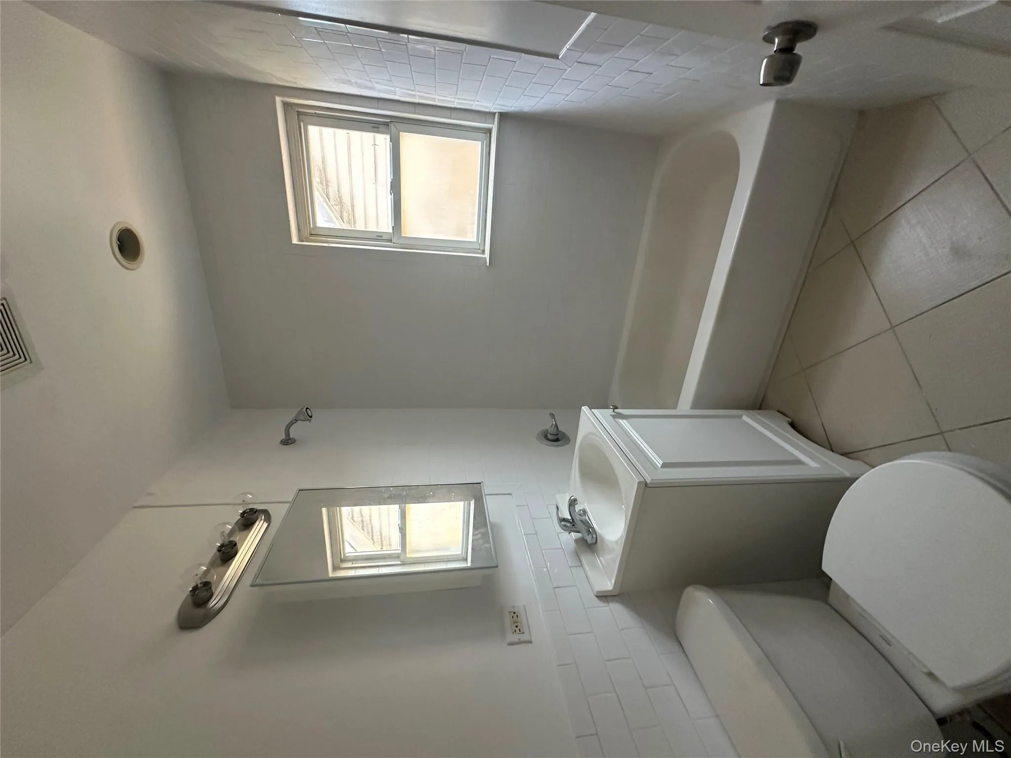 Bathroom with tile walls, light tile patterned flooring, vanity, and tub / shower combination Bathroom with tile walls, light tile patterned flooring, vanity, and tub / shower combination