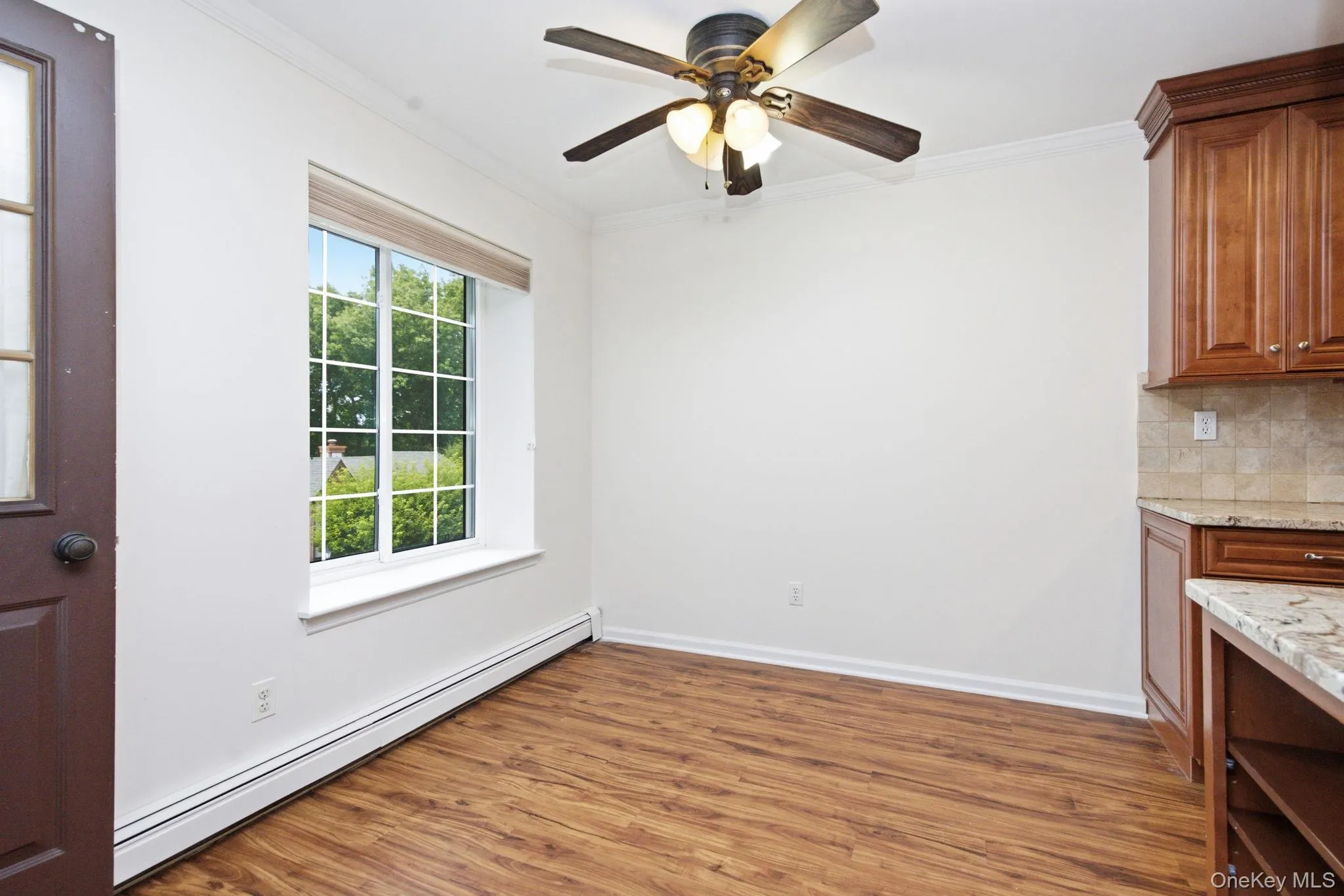 The dining area is bright and open, with a large picture window pulling in green views, warm flooring underfoot, a ceiling fan overhead, and a natural flow into the kitchen just steps away. The dining area is bright and open, with a large picture window pulling in green views, warm flooring underfoot, a ceiling fan overhead, and a natural flow into the kitchen just steps away.