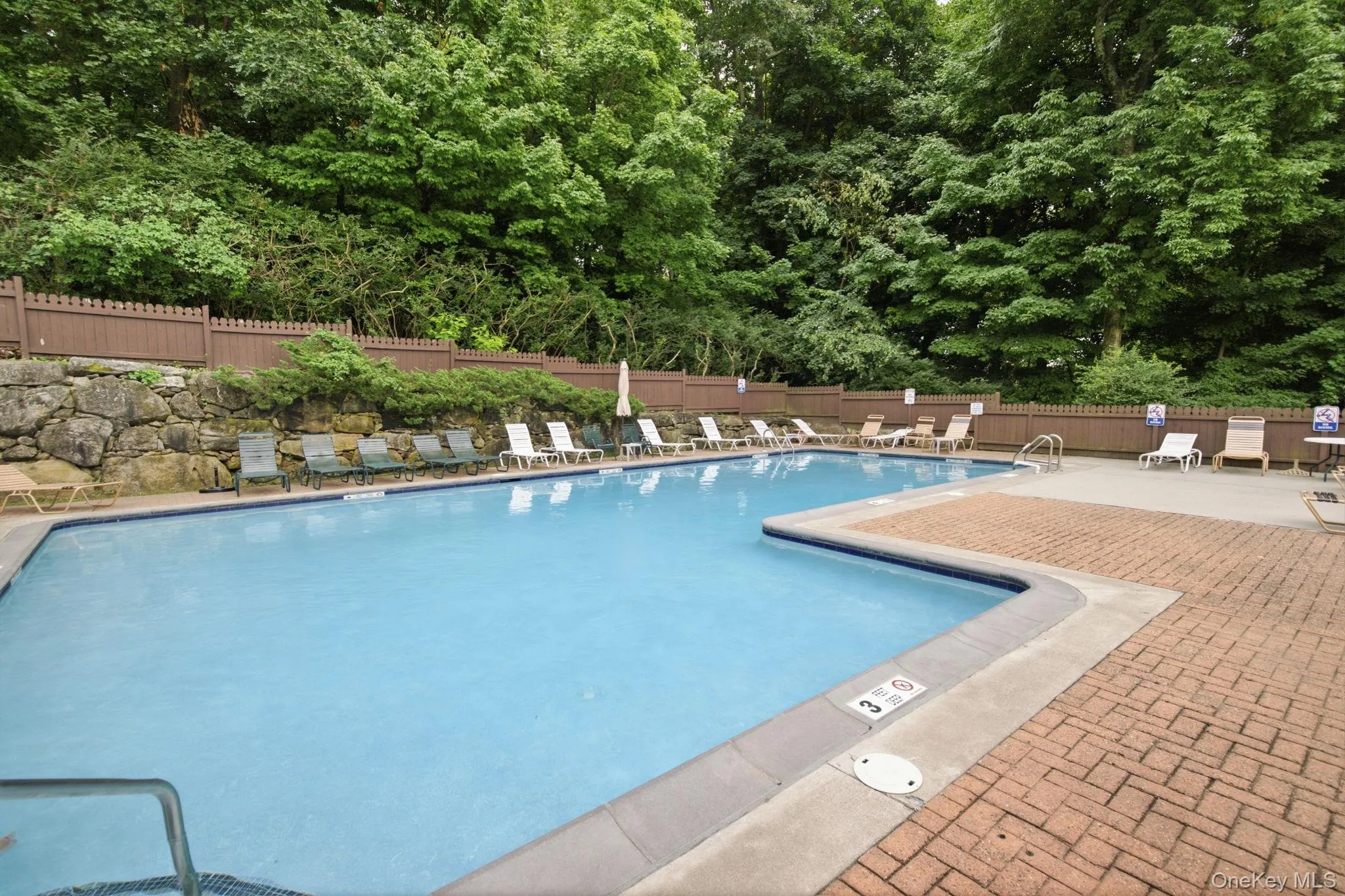 The sparkling in-ground pool is framed by lounge chairs, mature trees, and original fieldstone walls, a private oasis tucked into the heart of the community that you get to call your own. The sparkling in-ground pool is framed by lounge chairs, mature trees, and original fieldstone walls, a private oasis tucked into the heart of the community that you get to call your own.