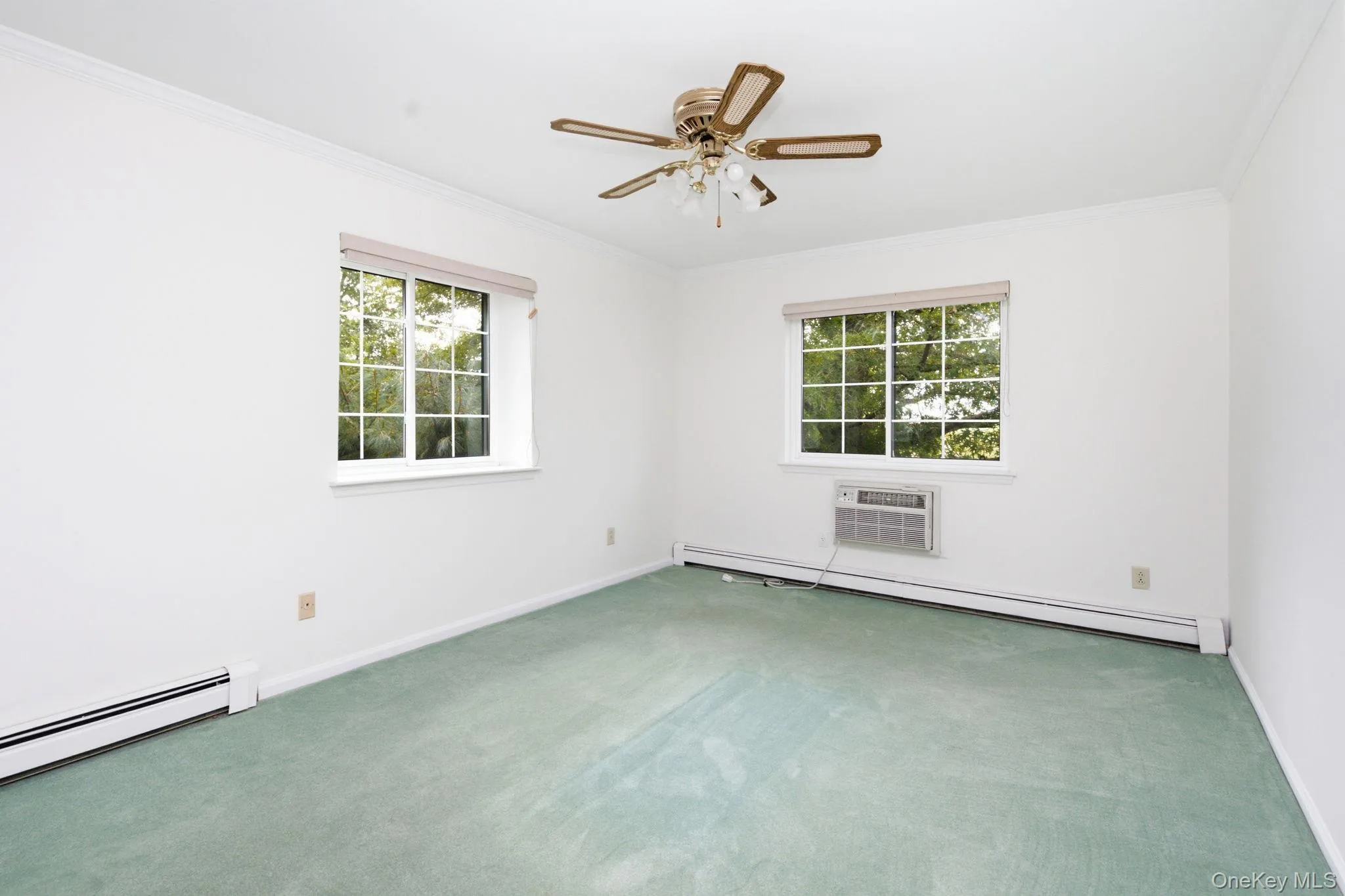 The spacious bedroom offers two windows, plush carpeting, a ceiling fan, and baseboard heat, creating a calm and private retreat at the top of the building with nothing but sky above. The spacious bedroom offers two windows, plush carpeting, a ceiling fan, and baseboard heat, creating a calm and private retreat at the top of the building with nothing but sky above.