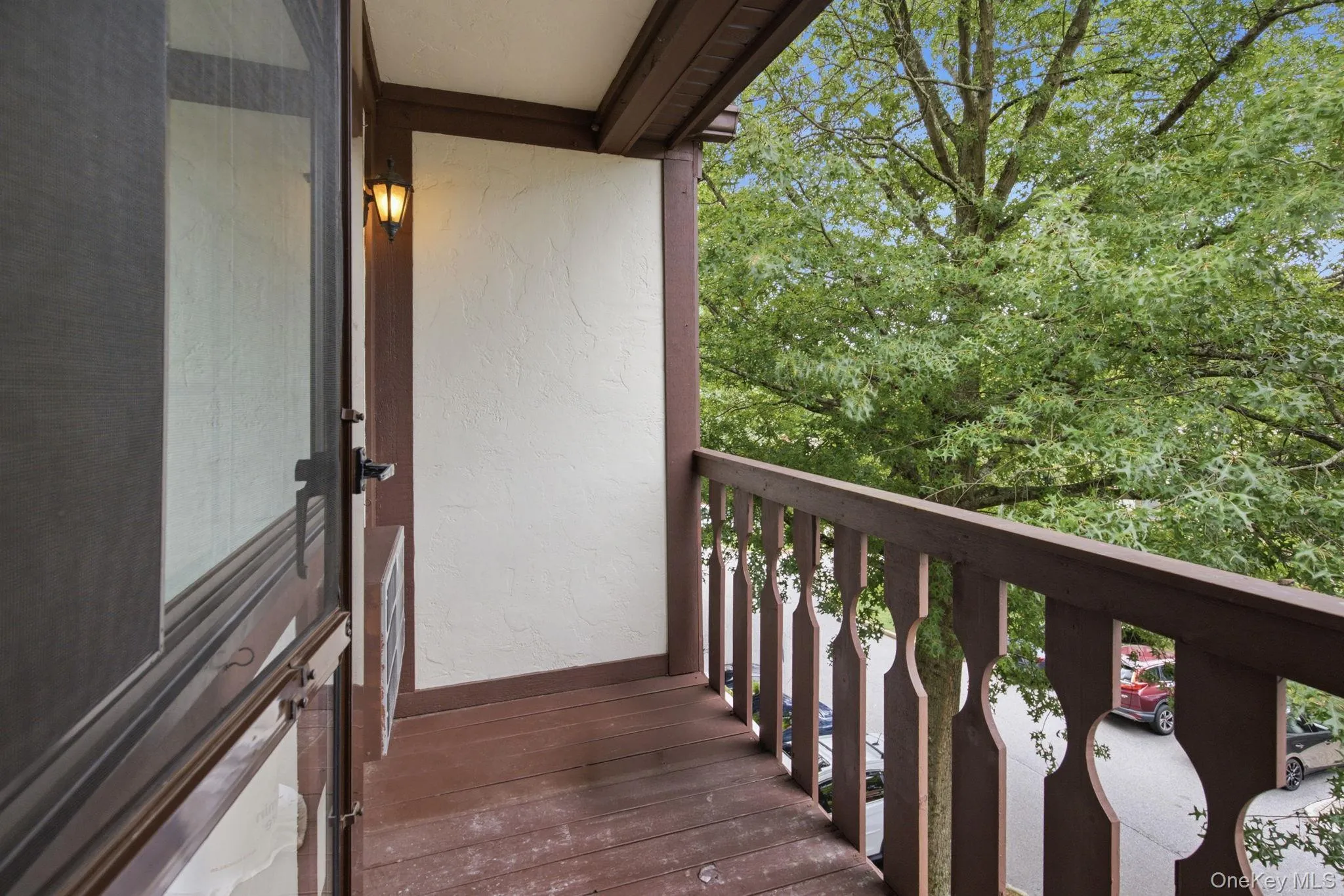 Step out to your private balcony and take in the mature tree canopy from above, a quiet outdoor escape with a wall sconce, decorative railing, and that top-floor sense of elevation and privacy. Step out to your private balcony and take in the mature tree canopy from above, a quiet outdoor escape with a wall sconce, decorative railing, and that top-floor sense of elevation and privacy.