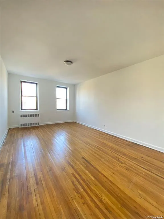 Spare room with light wood-type flooring and radiator heating unit Spare room with light wood-type flooring and radiator heating unit