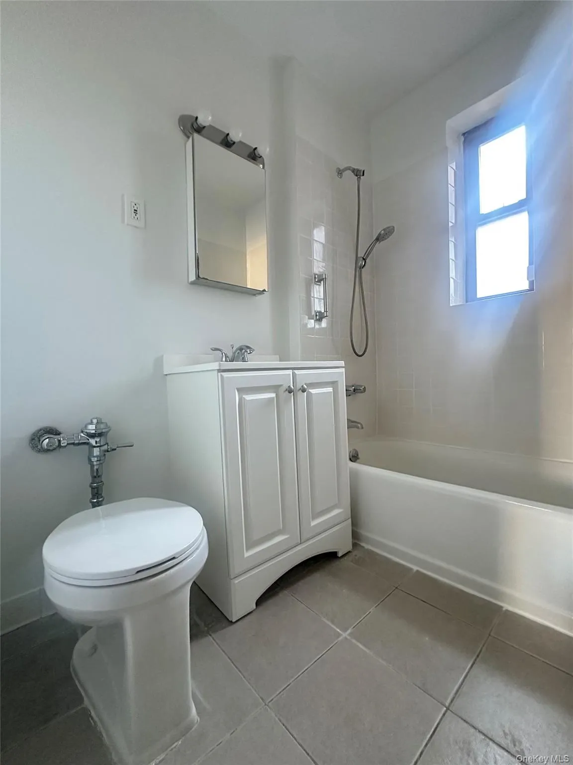 Full bathroom featuring light tile patterned floors, vanity, and bathtub / shower combination Full bathroom featuring light tile patterned floors, vanity, and bathtub / shower combination