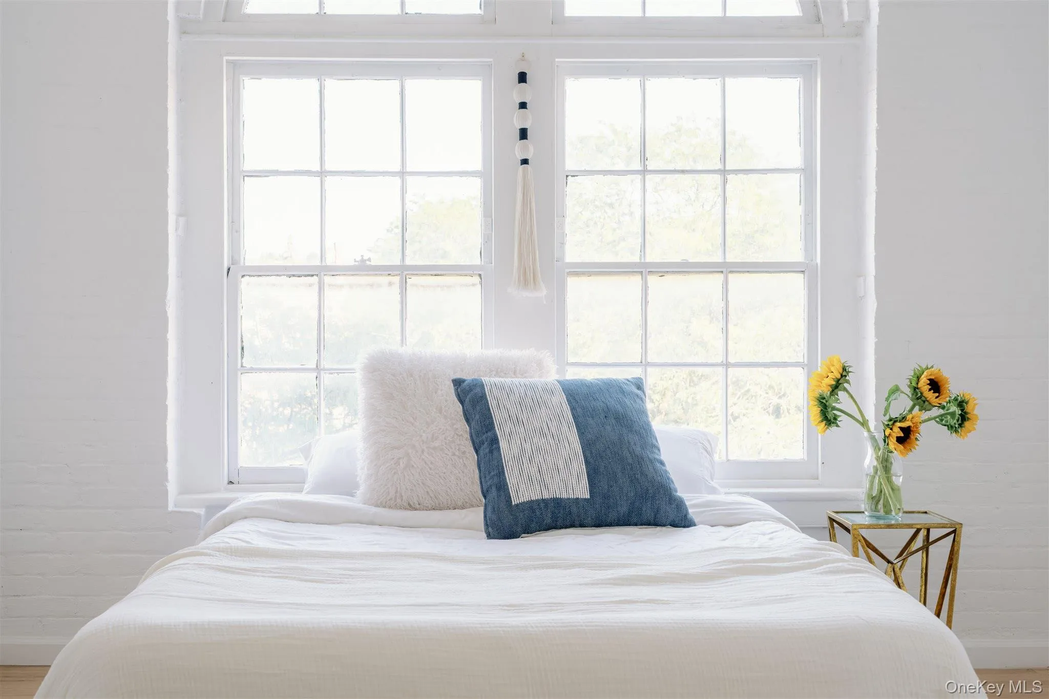Bedroom featuring multiple windows and wood finished floors Bedroom featuring multiple windows and wood finished floors