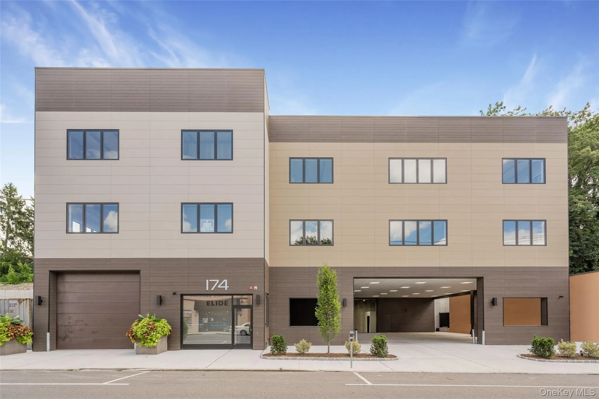 View of building exterior featuring driveway and a garage View of building exterior featuring driveway and a garage