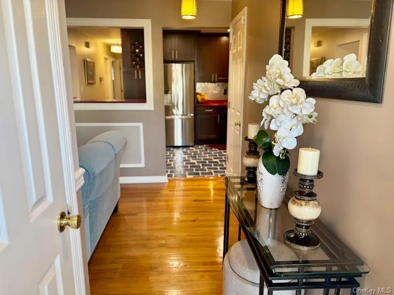 Corridor featuring light wood-type flooring and baseboards Corridor featuring light wood-type flooring and baseboards