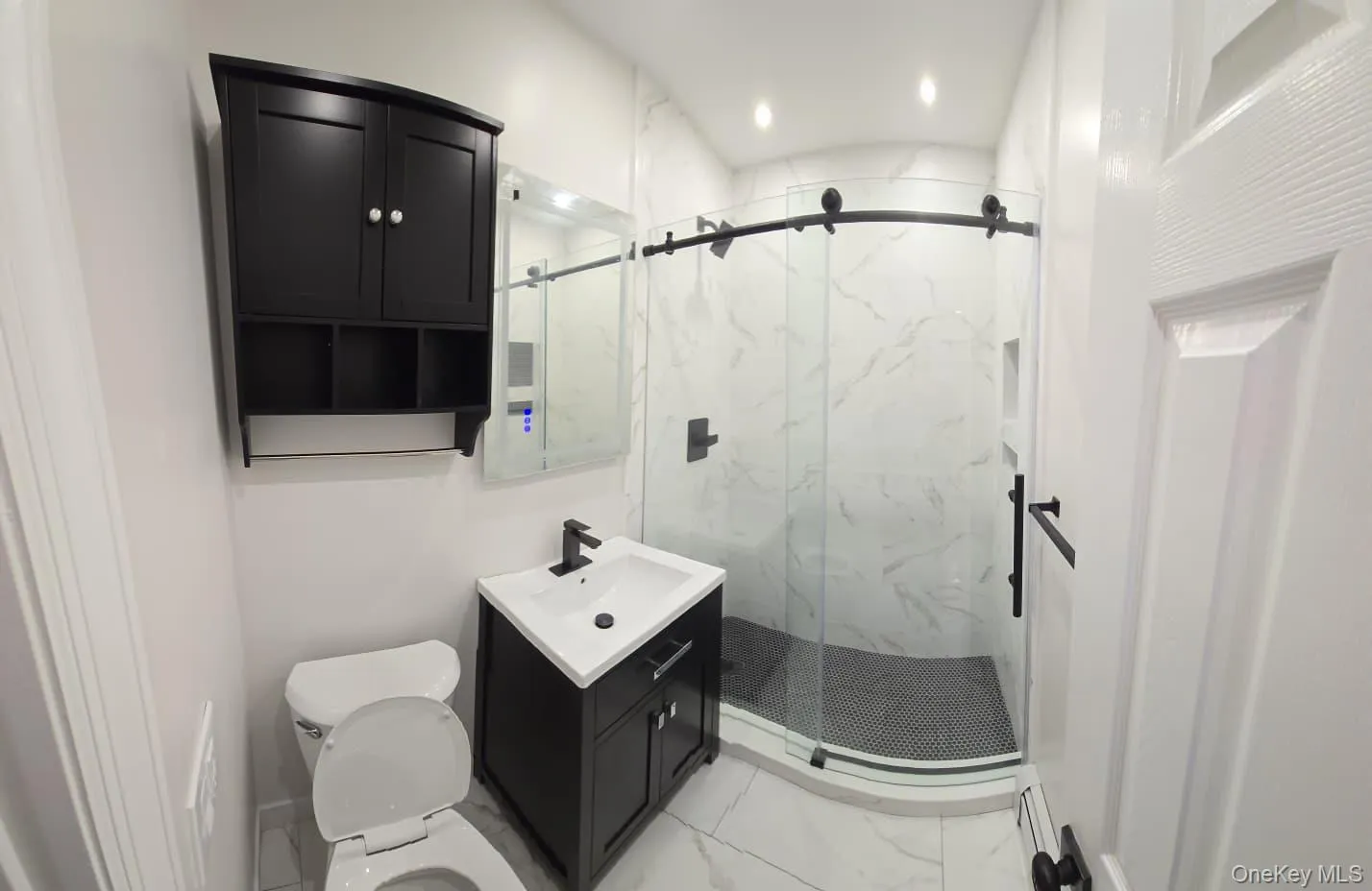 Full bath with vanity, a marble finish shower, light marble finish floors, and recessed lighting Full bath with vanity, a marble finish shower, light marble finish floors, and recessed lighting