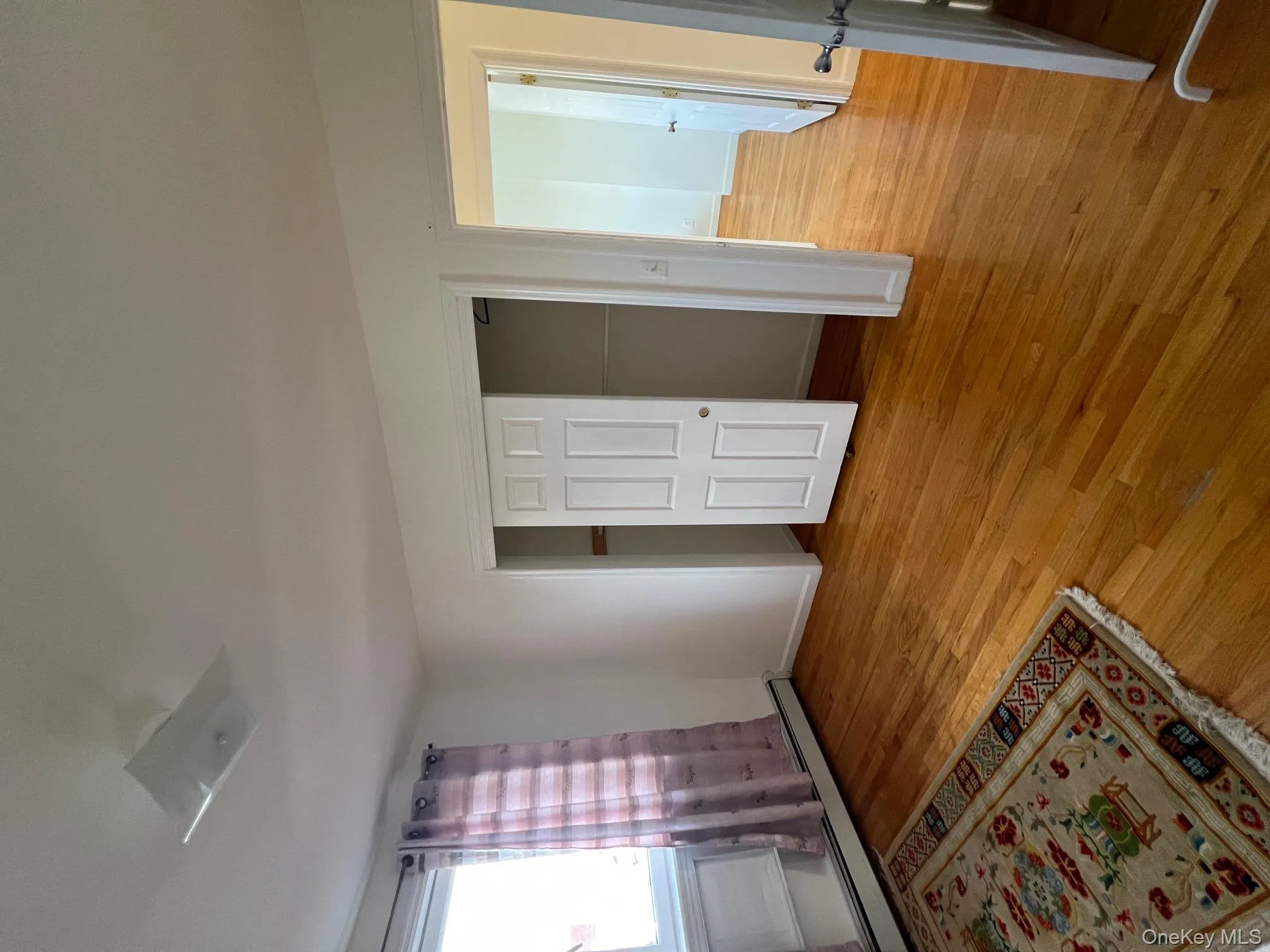 Unfurnished bedroom with a baseboard heating unit, light wood-style floors, and a closet Unfurnished bedroom with a baseboard heating unit, light wood-style floors, and a closet