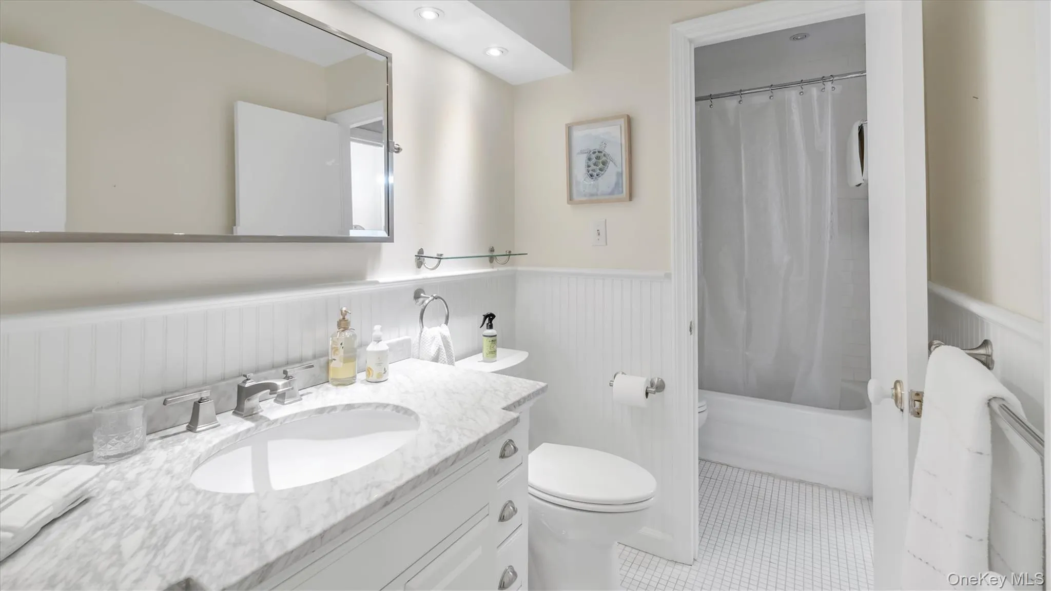Bathroom with vanity, a wainscoted wall, shower / bath combo with shower curtain, light tile patterned floors, and recessed lighting Bathroom with vanity, a wainscoted wall, shower / bath combo with shower curtain, light tile patterned floors, and recessed lighting