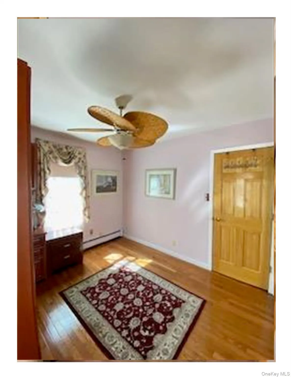 Foyer entrance with light wood-style flooring, ceiling fan, and a baseboard radiator Foyer entrance with light wood-style flooring, ceiling fan, and a baseboard radiator