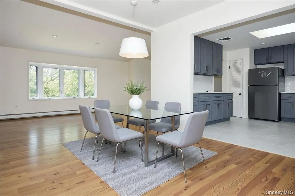 Dining space with light wood-style floors, a baseboard heating unit, recessed lighting, and a skylight Dining space with light wood-style floors, a baseboard heating unit, recessed lighting, and a skylight