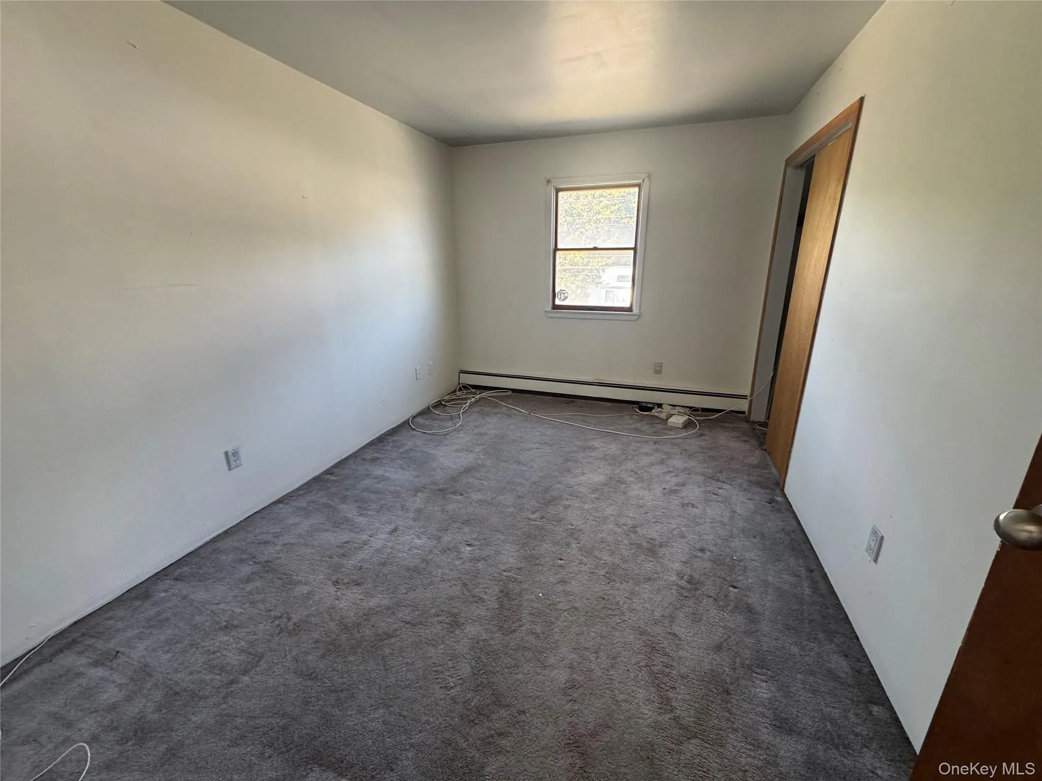Carpeted spare room featuring a baseboard radiator Carpeted spare room featuring a baseboard radiator