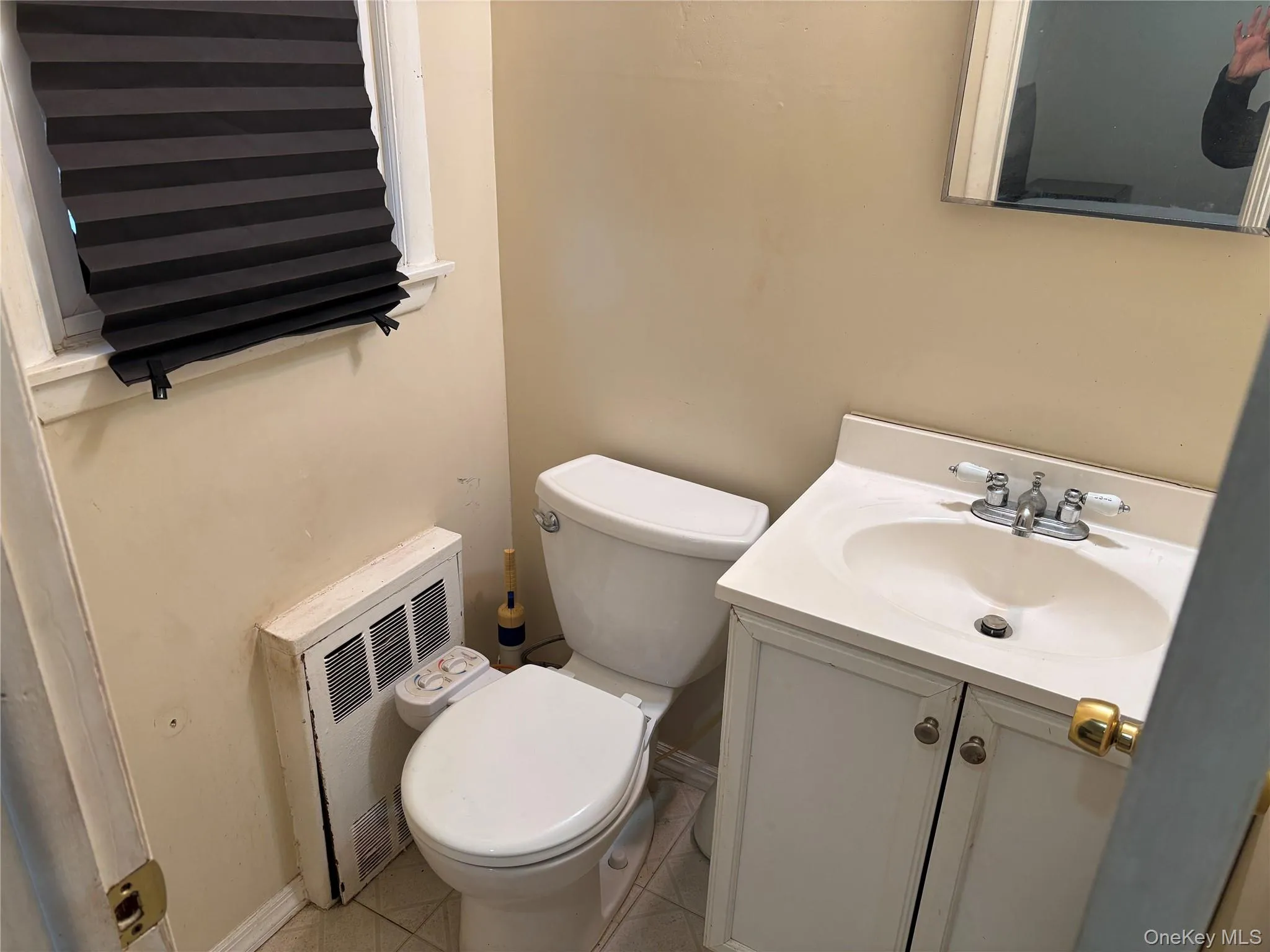 Bathroom with vanity, light tile patterned floors, and radiator Bathroom with vanity, light tile patterned floors, and radiator