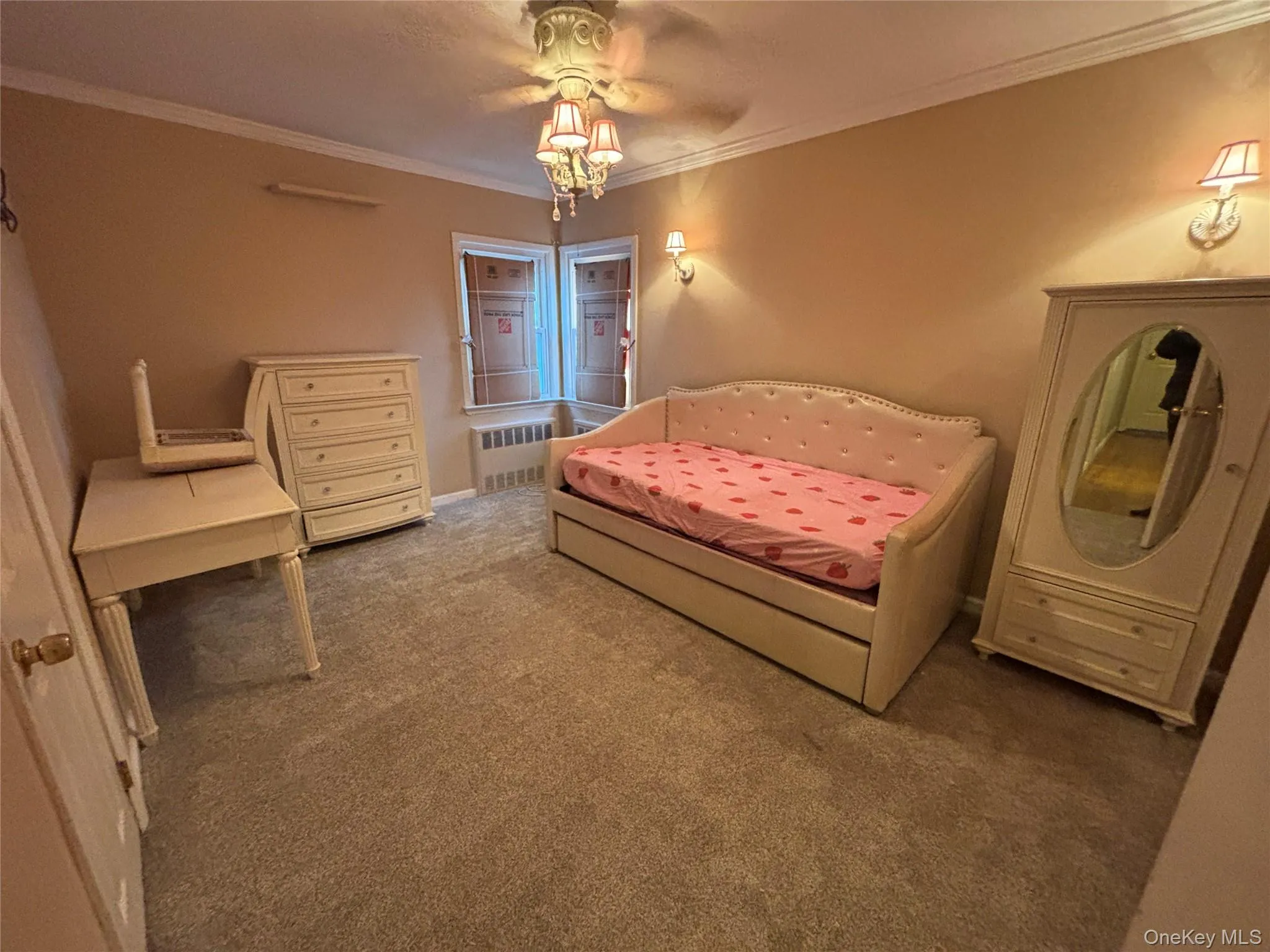 Bedroom featuring ornamental molding, carpet floors, and radiator Bedroom featuring ornamental molding, carpet floors, and radiator