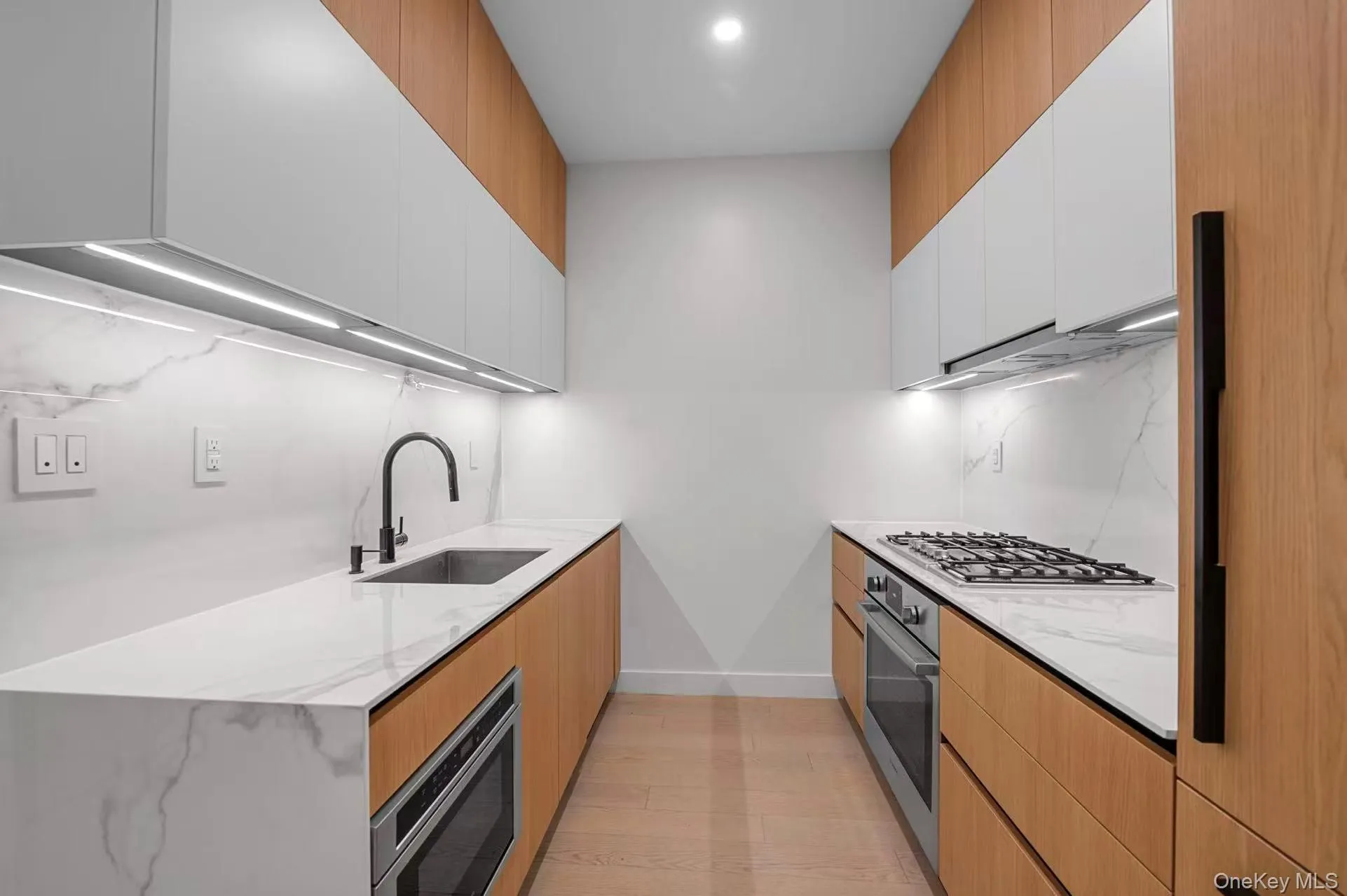 Kitchen featuring light stone countertops, modern cabinets, and white cabinets Kitchen featuring light stone countertops, modern cabinets, and white cabinets