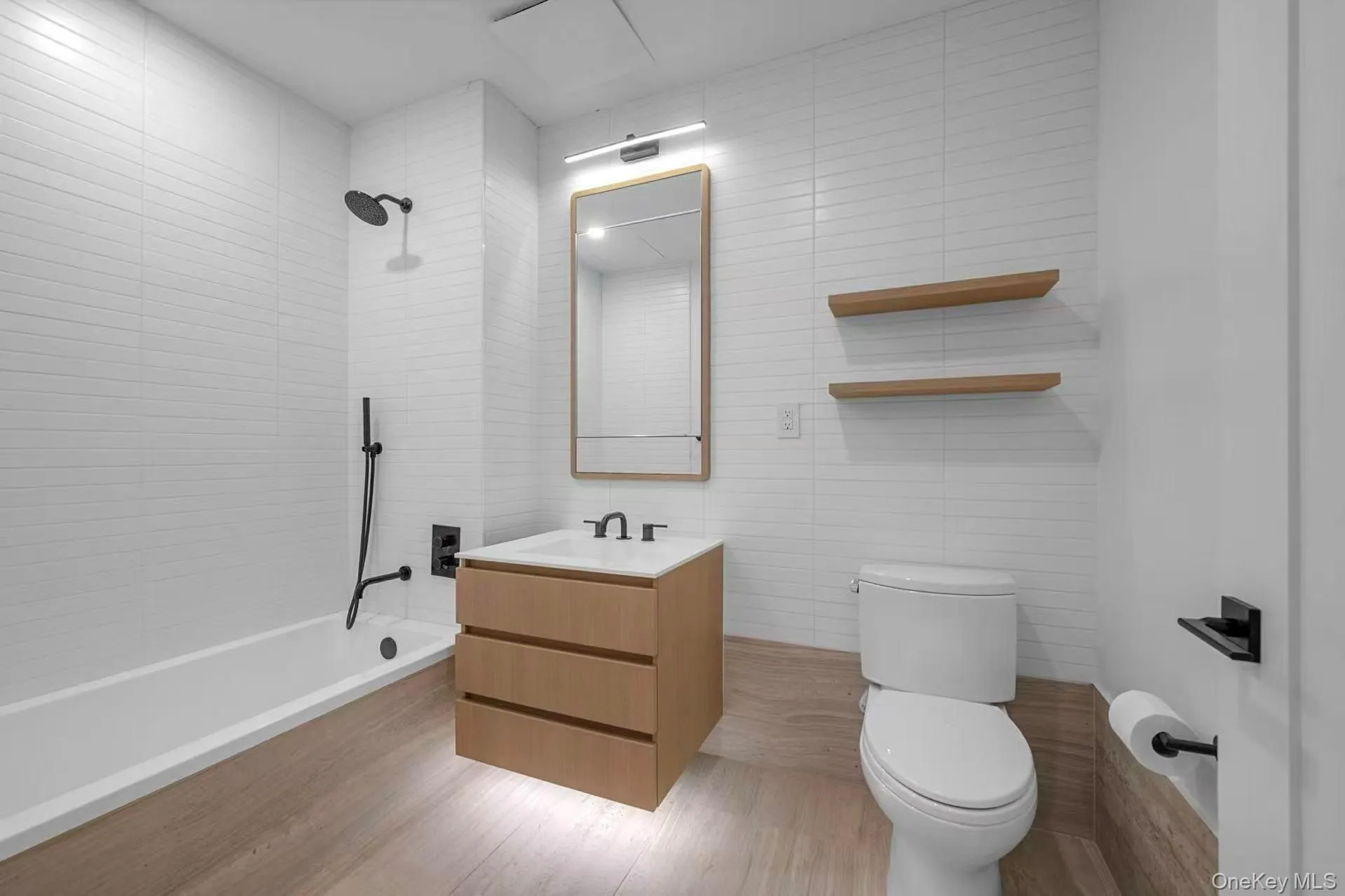 Bathroom with tile walls, vanity, and tiled shower / bath Bathroom with tile walls, vanity, and tiled shower / bath